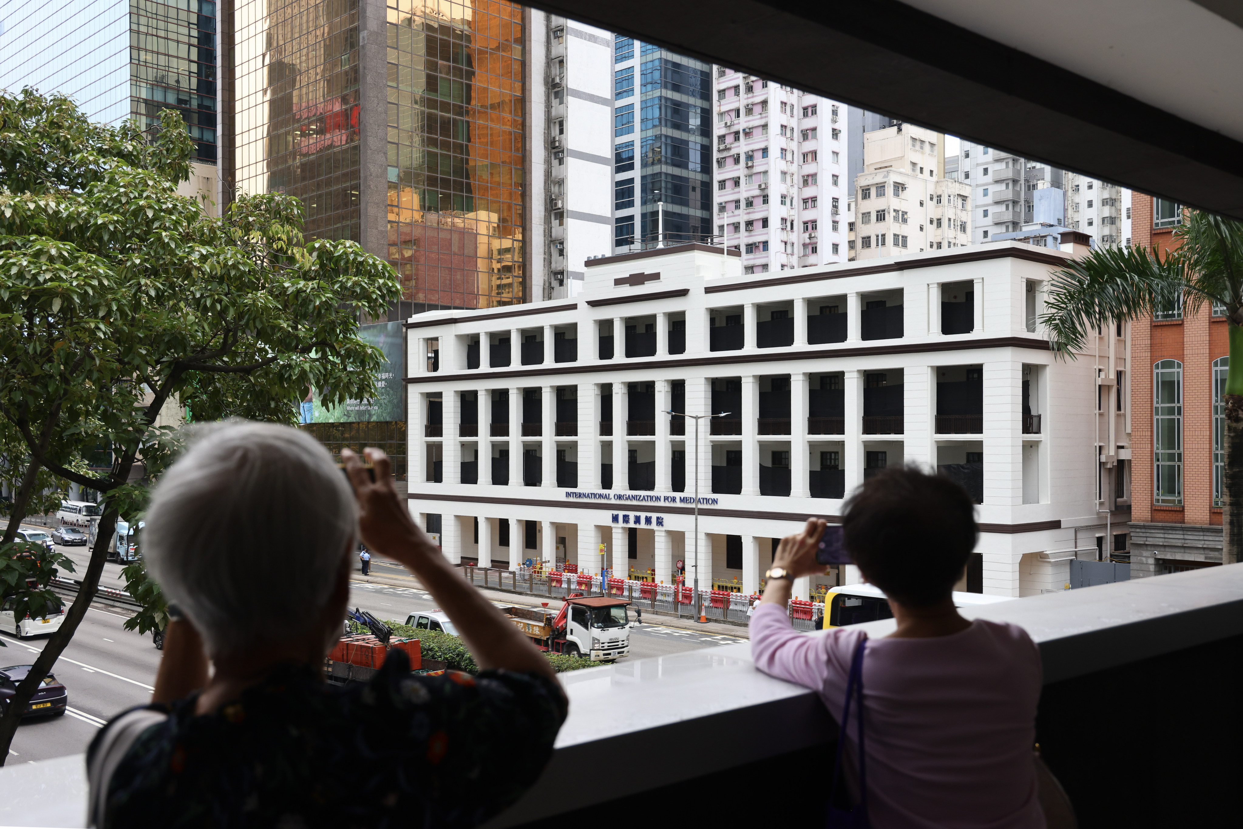 Pedestrians take pictures of the International Organisation for Mediation’s Hong Kong headquarters, in Wan Chai, on May 30. Photo: Dickson Lee