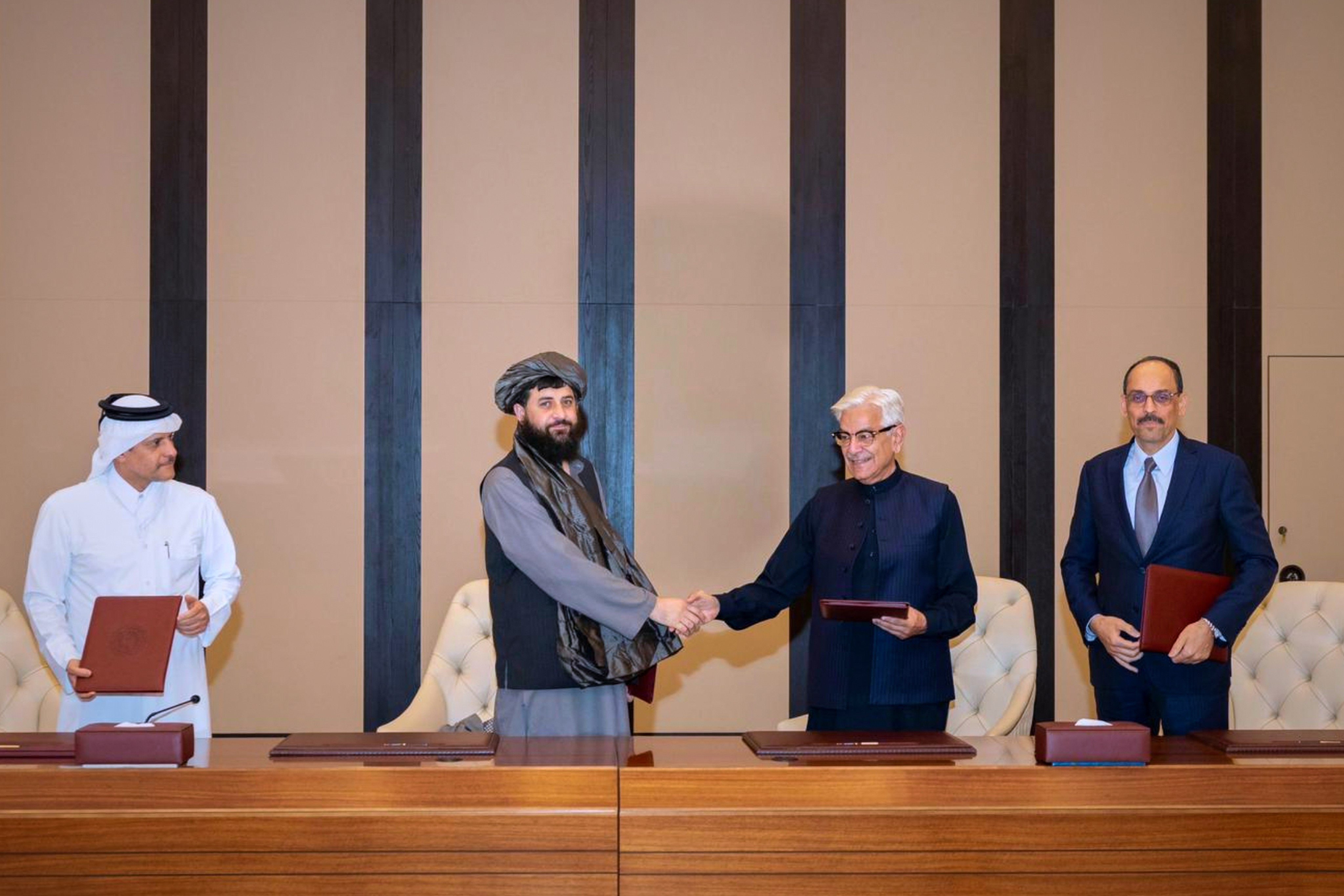 Pakistani Defence Minister Khawaja Asif (right) and Afghan Defence Minister Mullah Muhammad Yaqoob shake hands after signing a ceasefire agreement in Doha, Qatar, on Sunday. Photo: AP