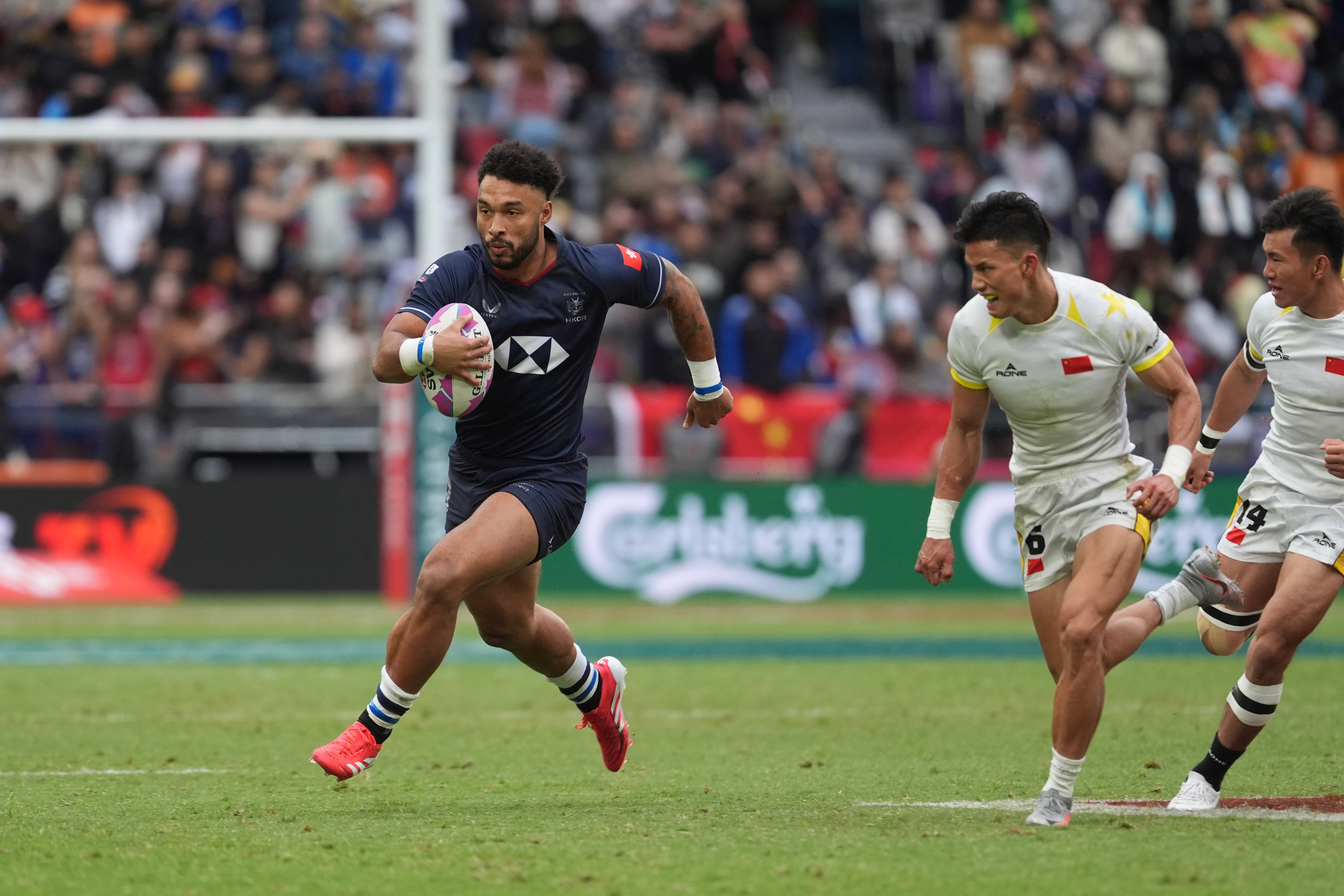Max Denmark races clear of two Chinese defenders at the 2025 Cathay/HSBC Hong Kong Sevens. Photo: Elson Li