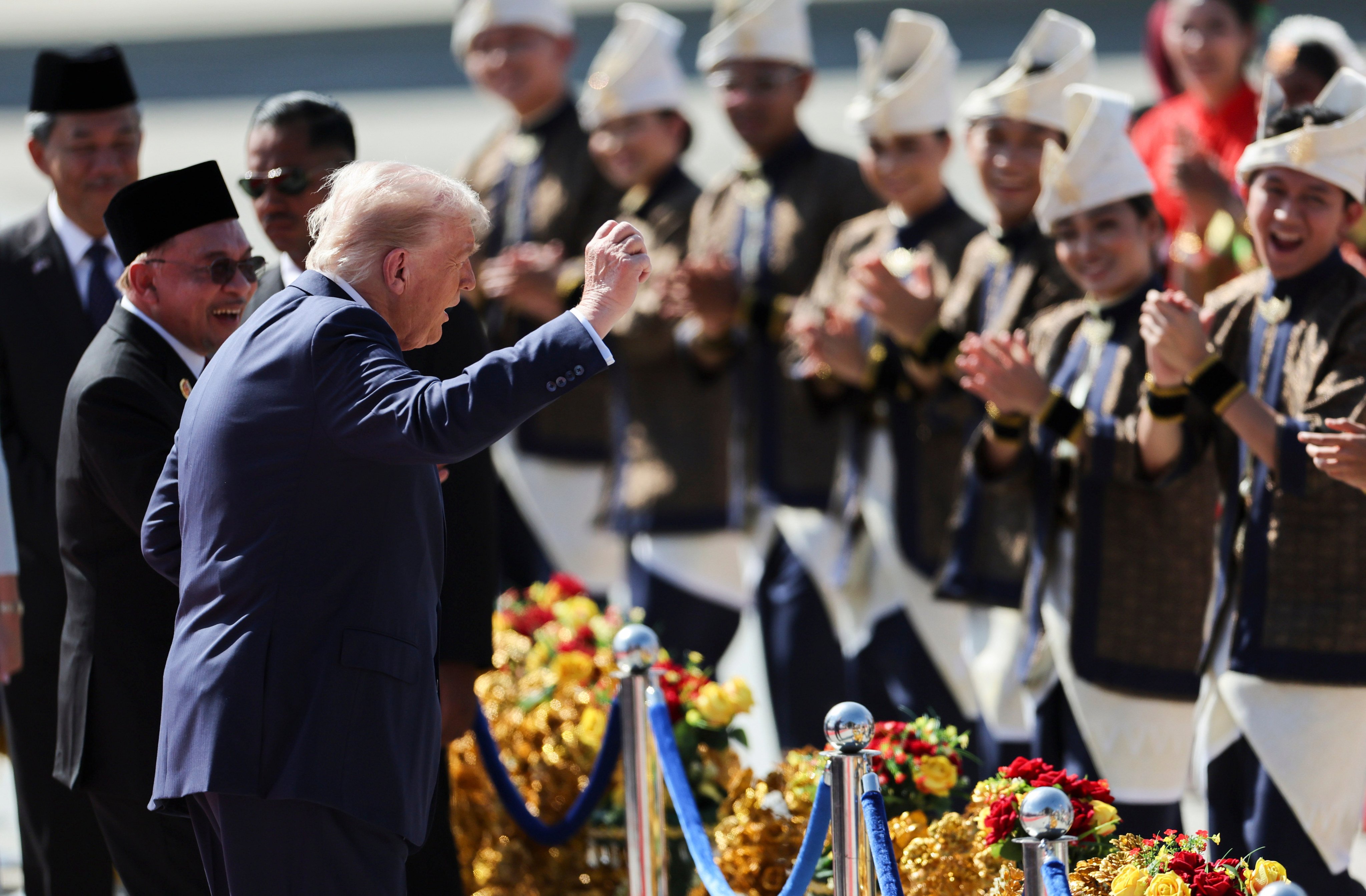 US President Donald Trump joins performers for a dance during a welcome ceremony next to Malaysia’s Prime Minister Anwar Ibrahim (left) at Kuala Lumpur International Airport on Sunday. Photo: AP