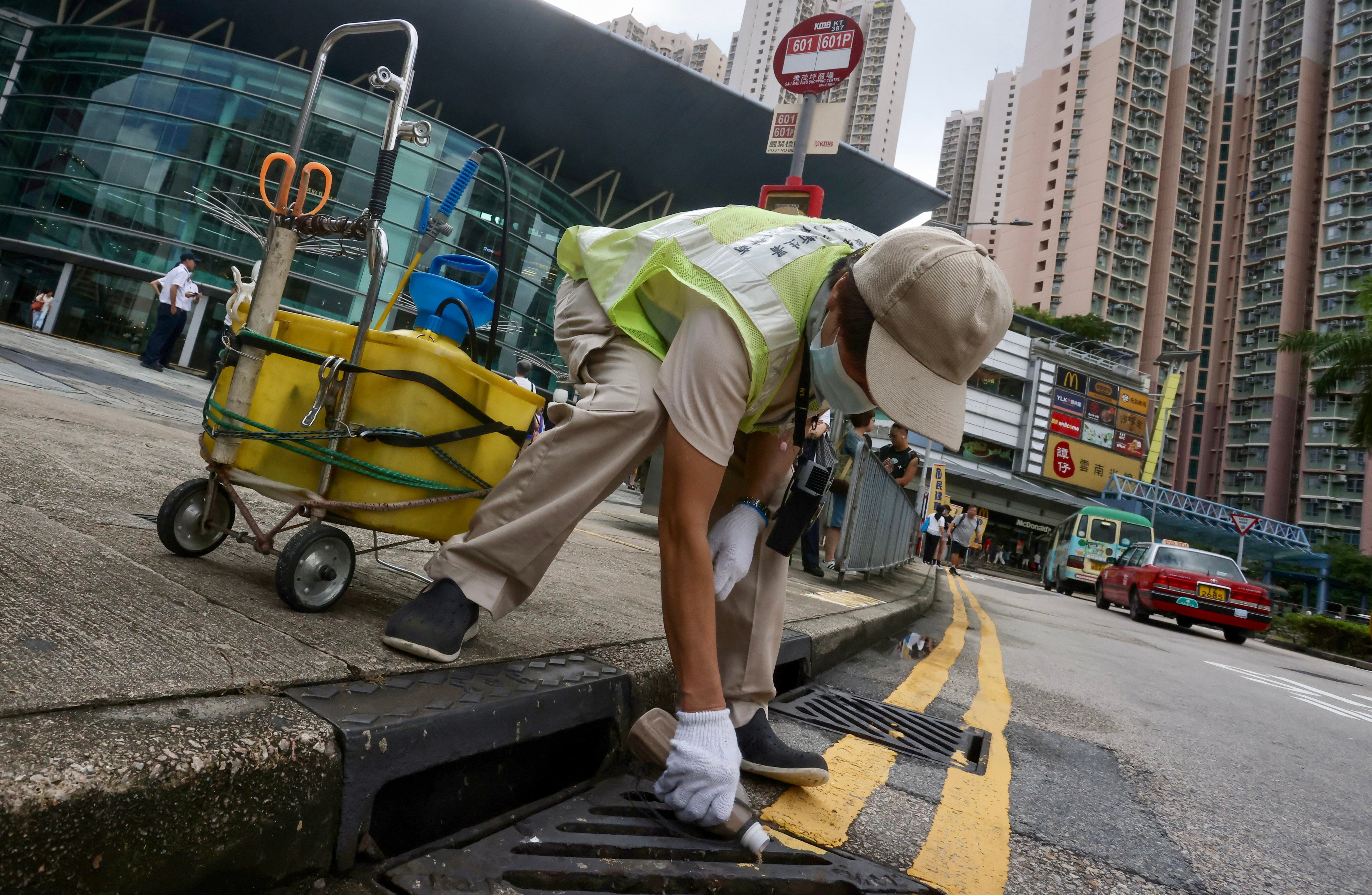 Workers perform anti-mosquito measures outside a shopping centre in Sau Mau Ping, on August 12. Photo: Jonathan Wong