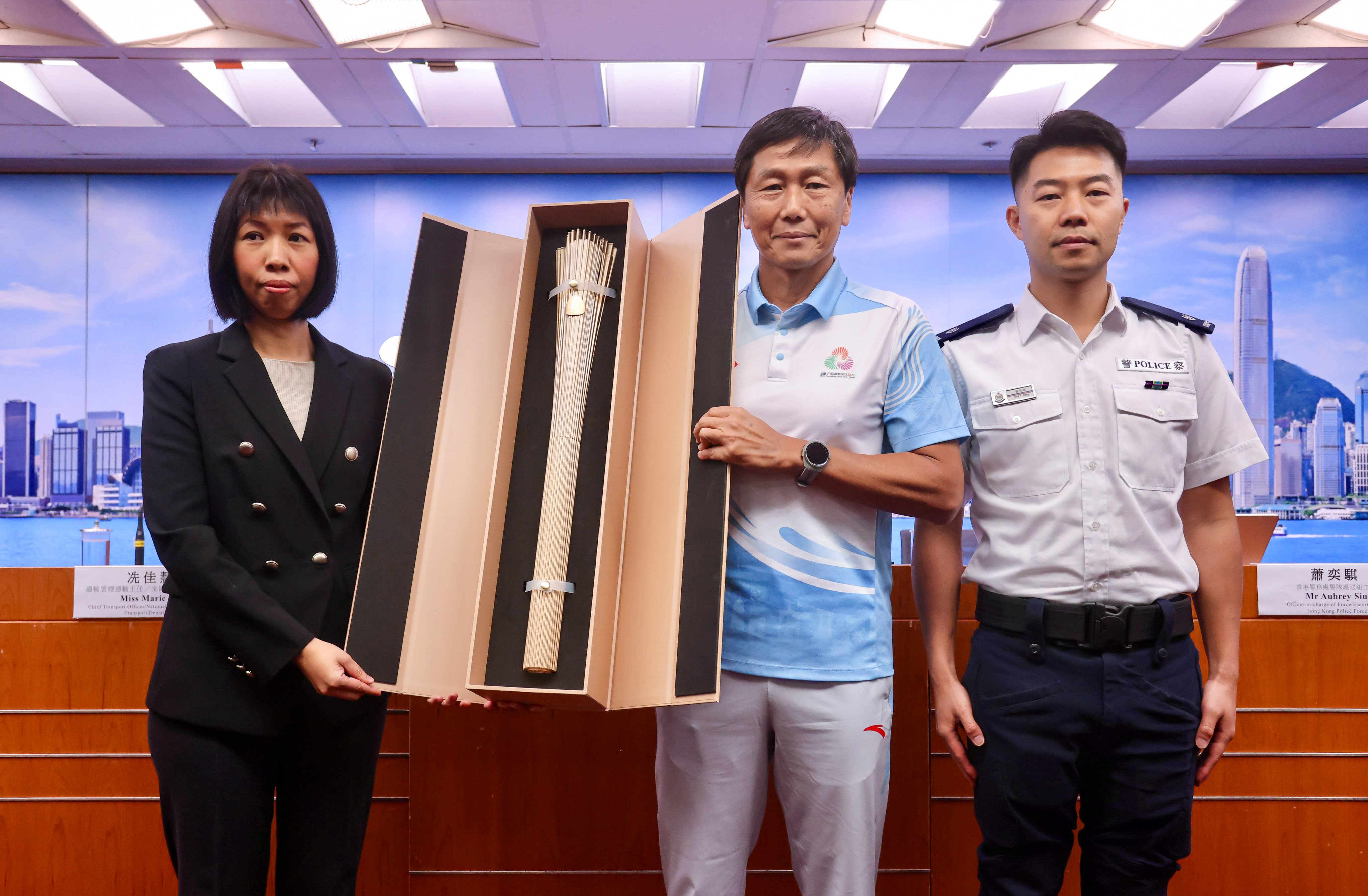 (From left) Marie Sin, Yeung Tak-keung and Superintendent Aubrey Siu with the torch for the relay. Photo: Jonathan Wong