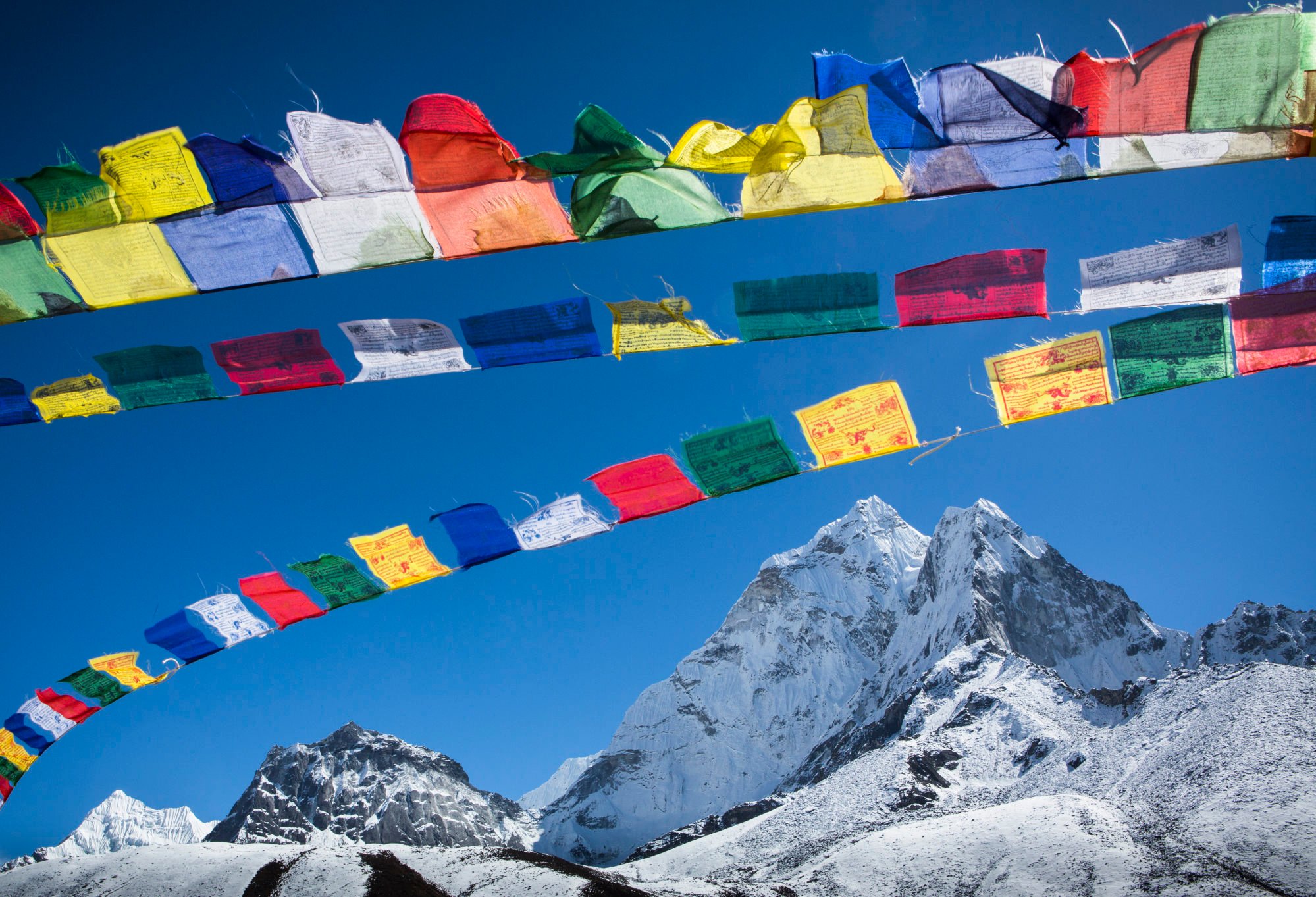 Colourful Buddhist prayer flags wave above Ama Dablam. Photo: Getty Images Colourful Buddhist prayer flags wave above Ama Dablam. Photo: Getty Images