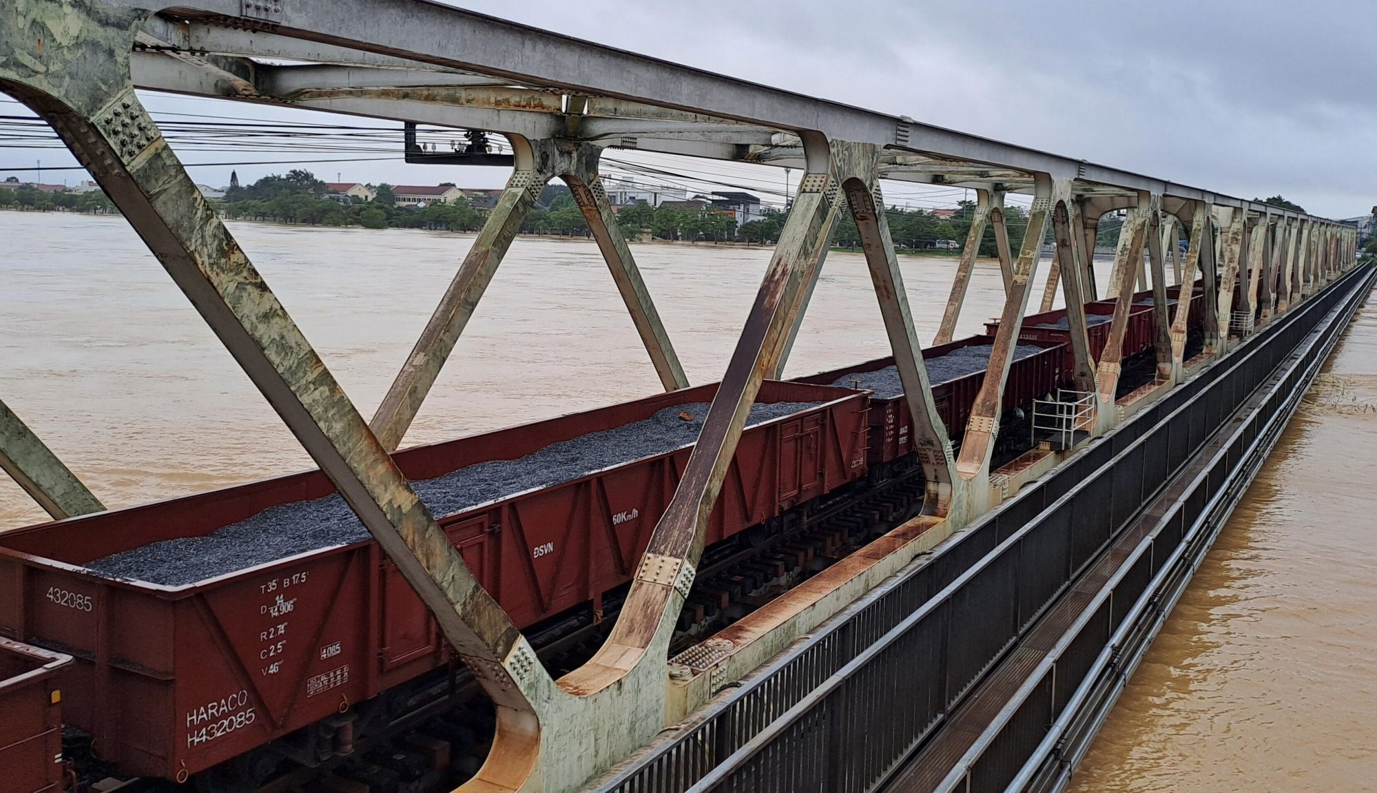 Train carriages laden with stones weigh down a railway bridge to secure the structure from being washed away by floodwaters in Hue on Tuesday. Photo: VNA/AP Train carriages laden with stones weigh down a railway bridge to secure the structure from being washed away by floodwaters in Hue on Tuesday. Photo: VNA/AP