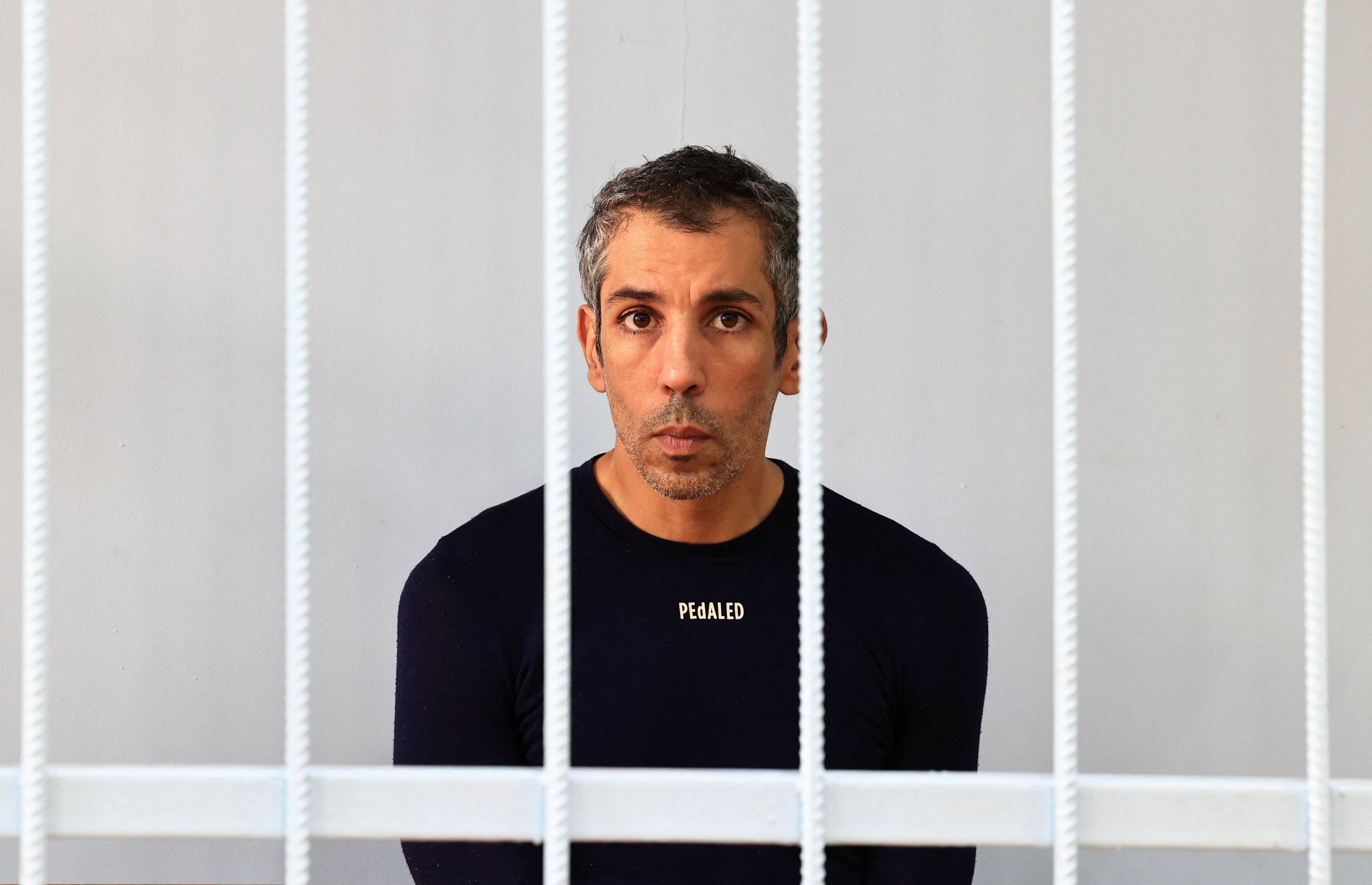 French cyclist Sofiane Sehili inside an enclosure for defendants before a court hearing in the far eastern settlement of Pogranichniy, Russia on Monday. Photo: Reuters