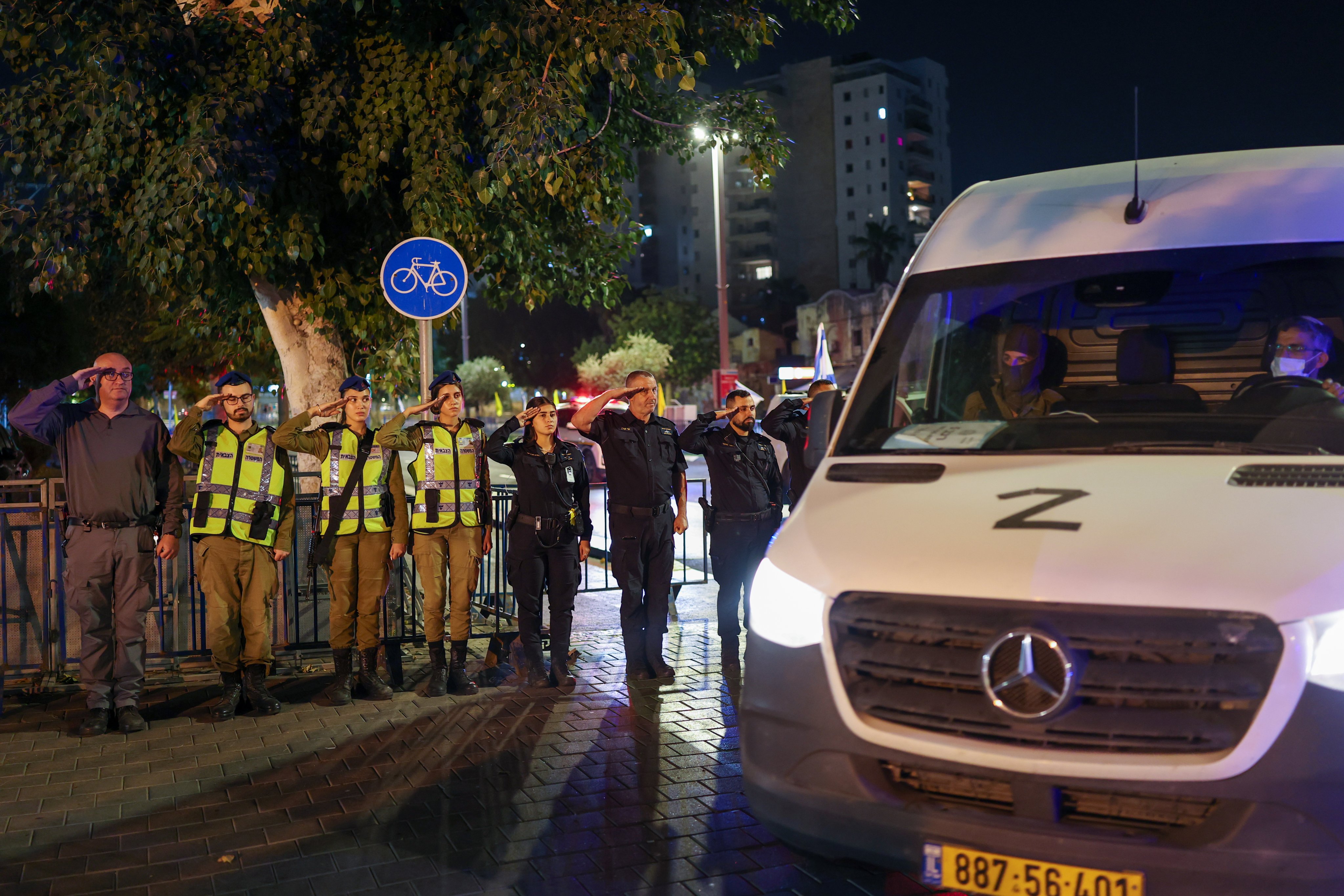 Israeli soldiers and police salute as a convoy carrying the body of a hostage arrives in Tel Aviv on Tuesday. Photo: EPA