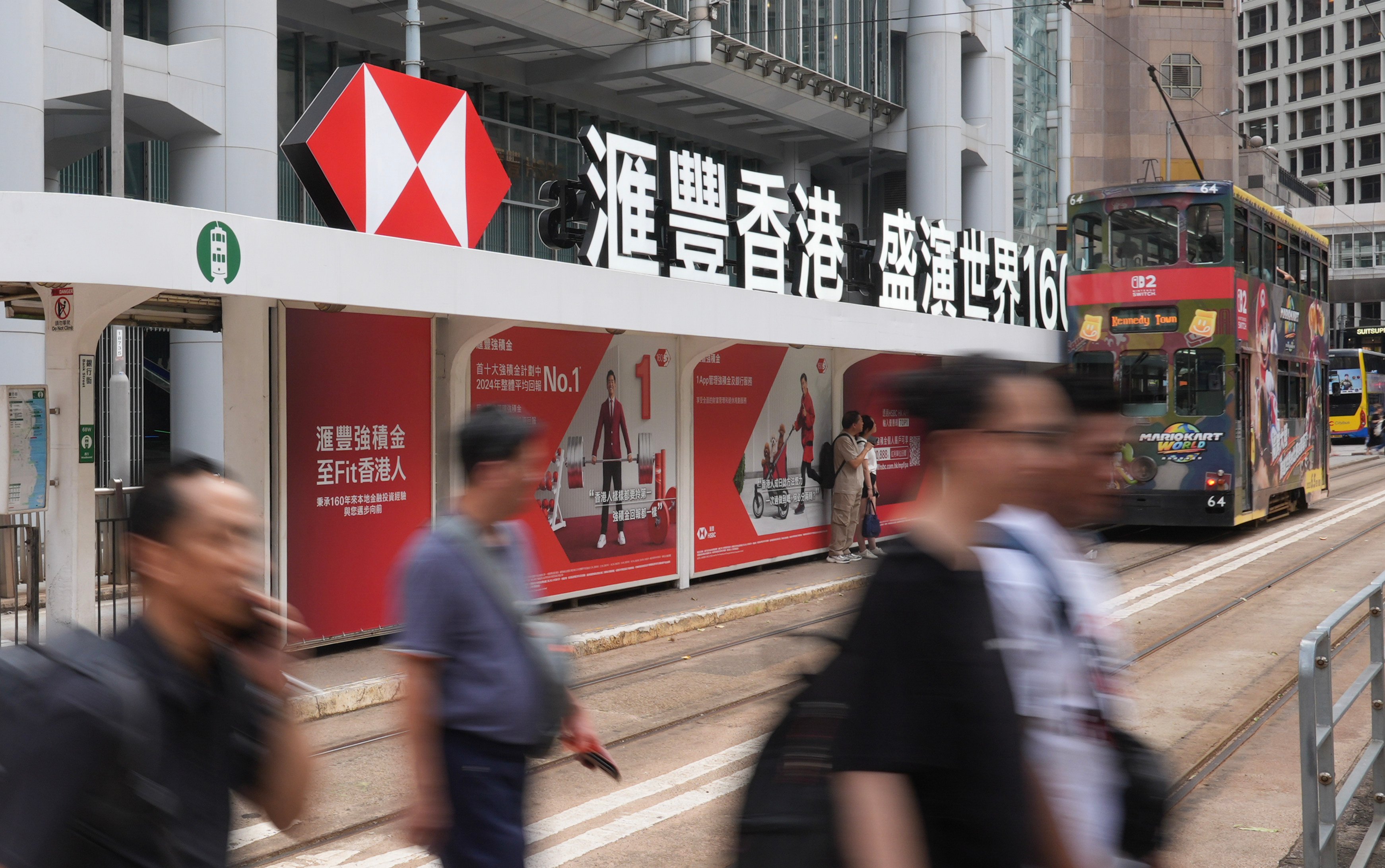 Pedestrians and a tram pass the HSBC building in Central on July 30, 2025. Photo: Eugene Lee