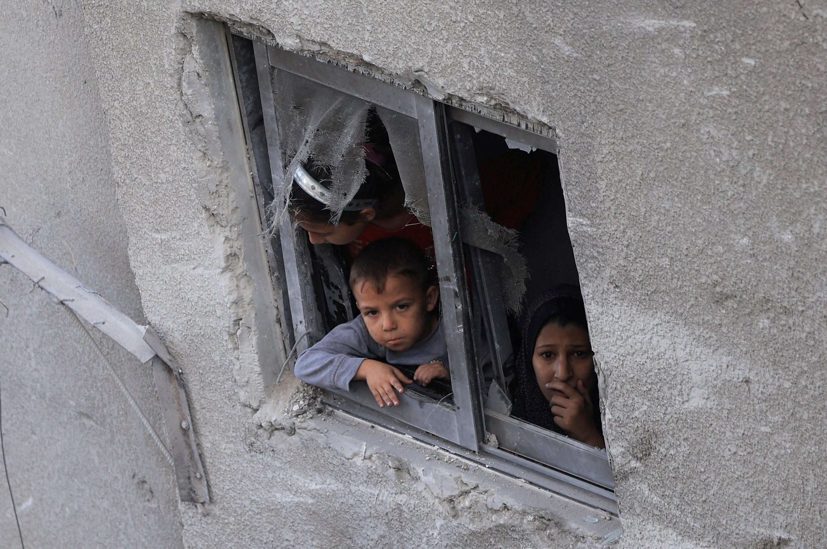 Palestinians look out of a window, near a house hit in an overnight Israeli strike, in Gaza City. Photo: Reuters