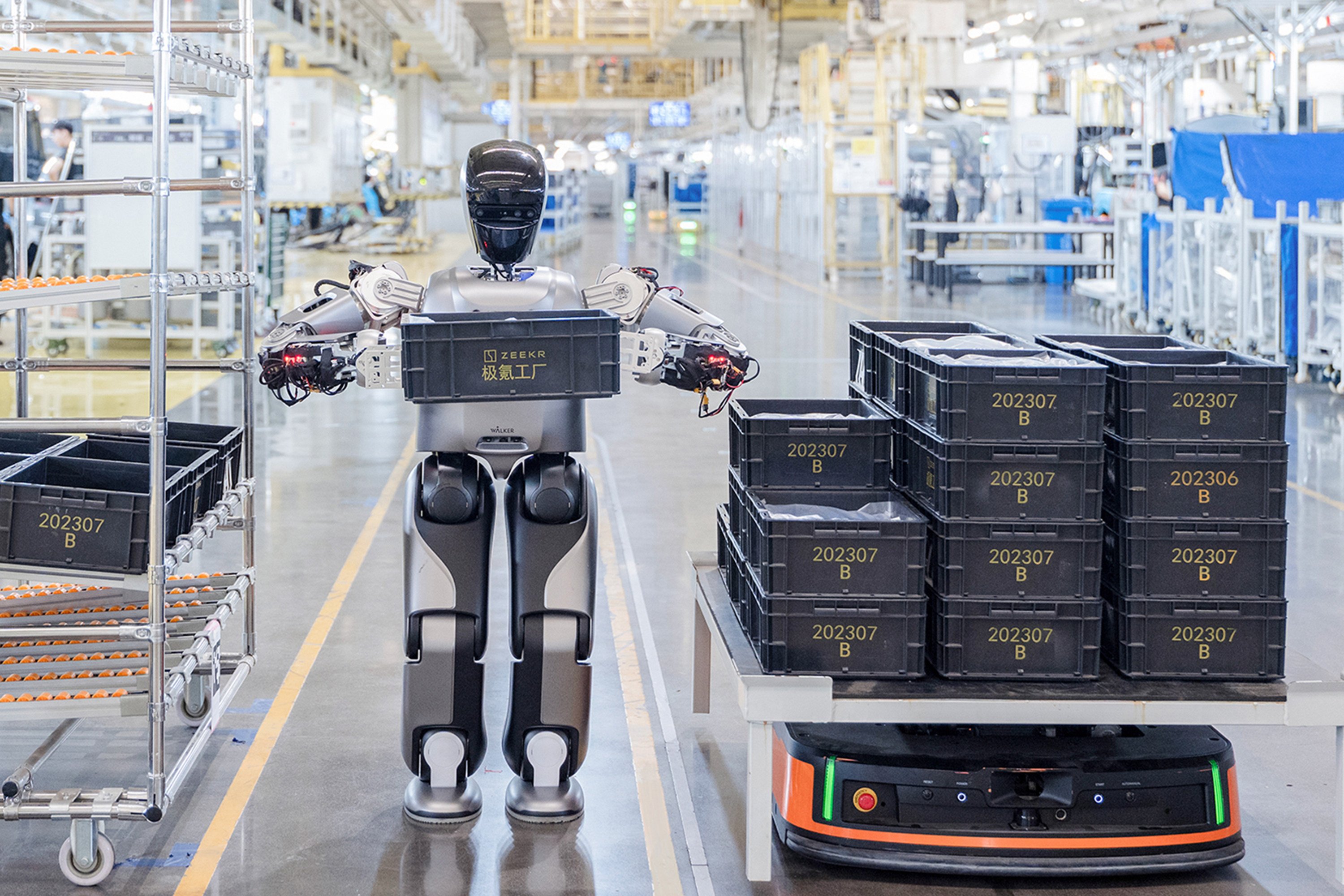 A humanoid robot “staff” called Walker S Lite, developed by UBTech, moves a heavy load onto an automated guided vehicle in Zeekr’s 5G-enabled smart factory on August 5, 2024, in Ningbo, Zhejiang province. Photo: VCG via Getty Images
