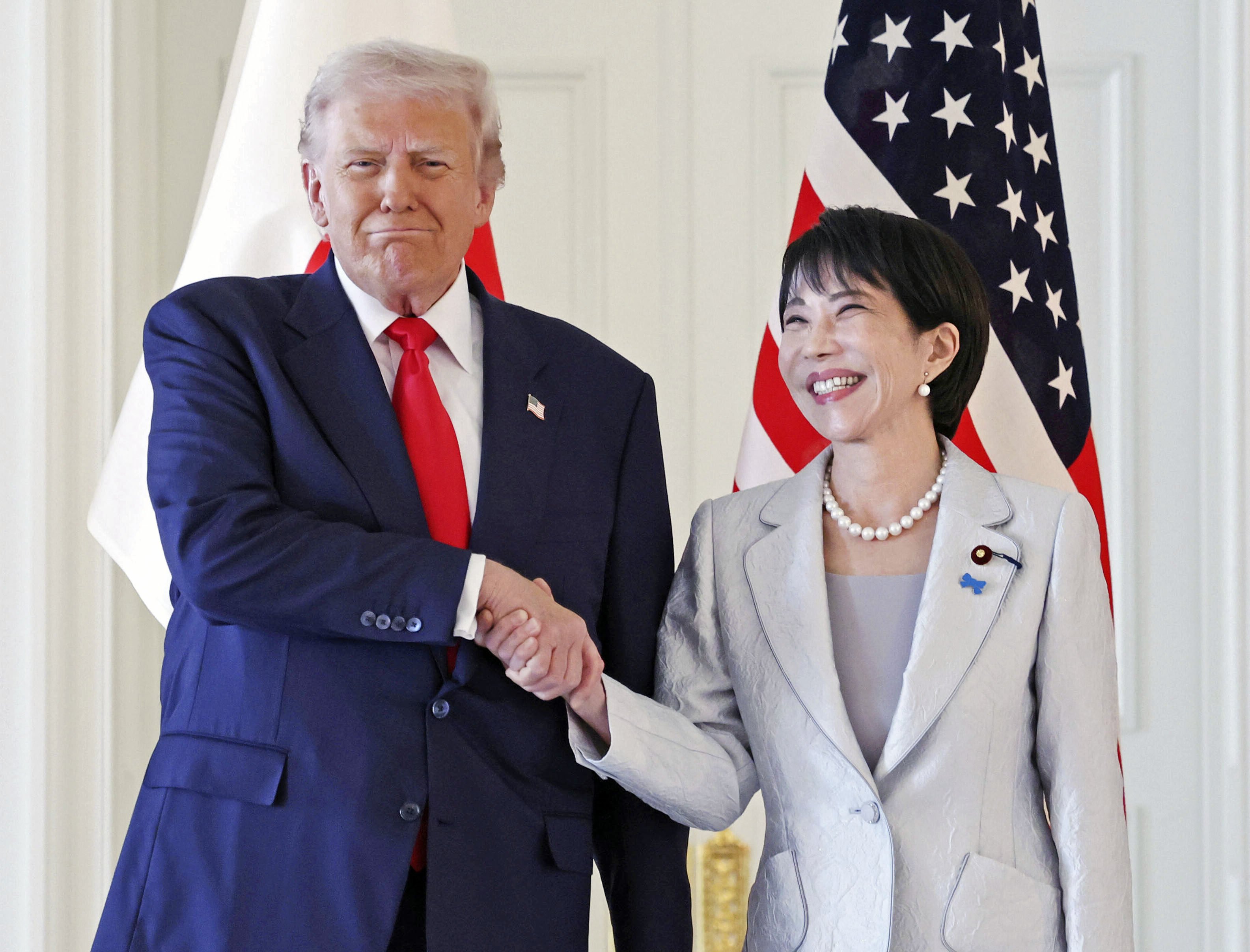 Japanese Prime Minister Sanae Takaichi (right) and US President Donald Trump shake hands ahead of their summit in Tokyo on Tuesday. Photo: Kyodo