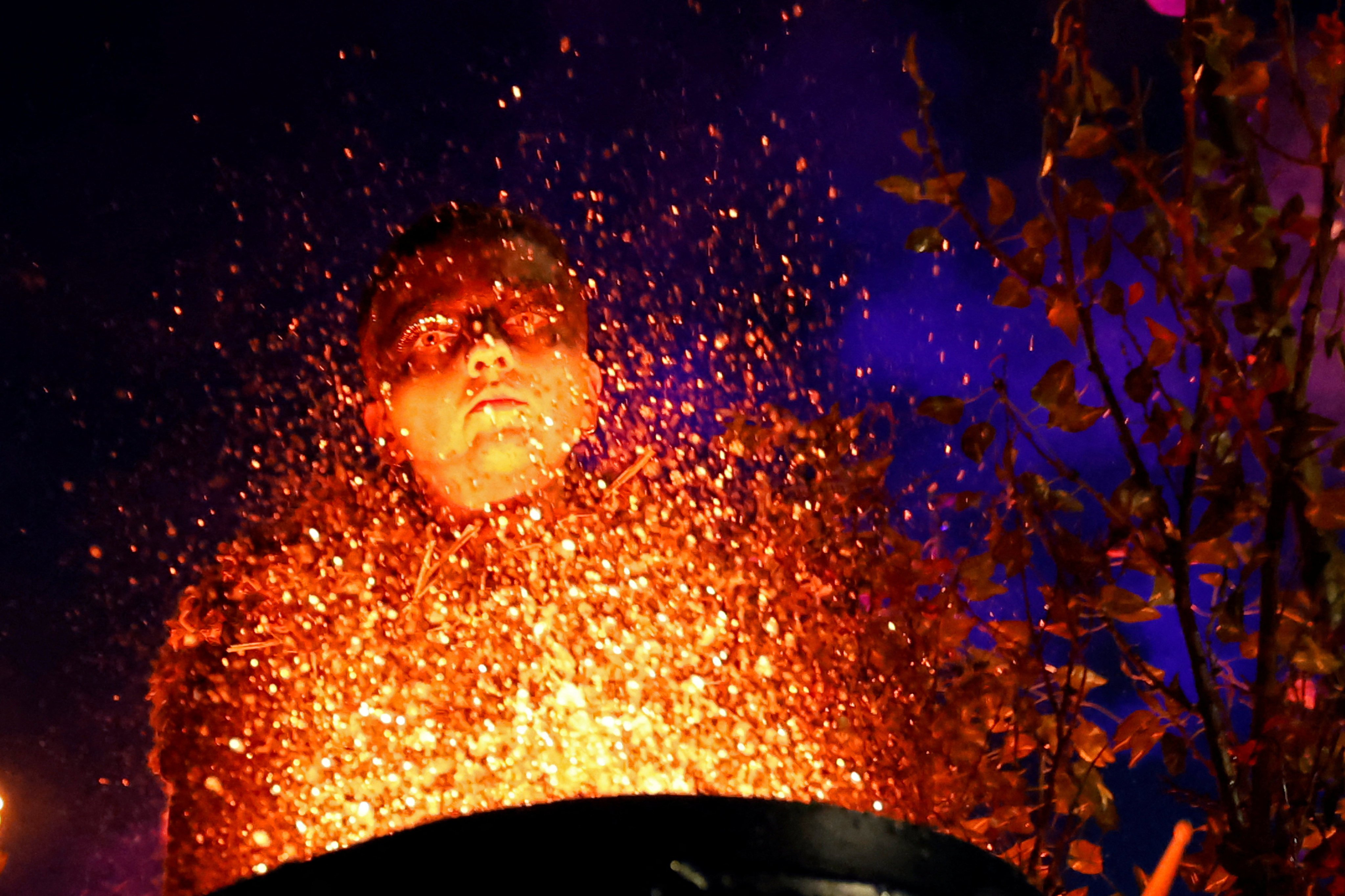 A performer in costume beats an illuminated drum covered with water, as part of the street theatre group Macnas’ Halloween parade in Galway, Ireland on October 26. Photo: Reuters
