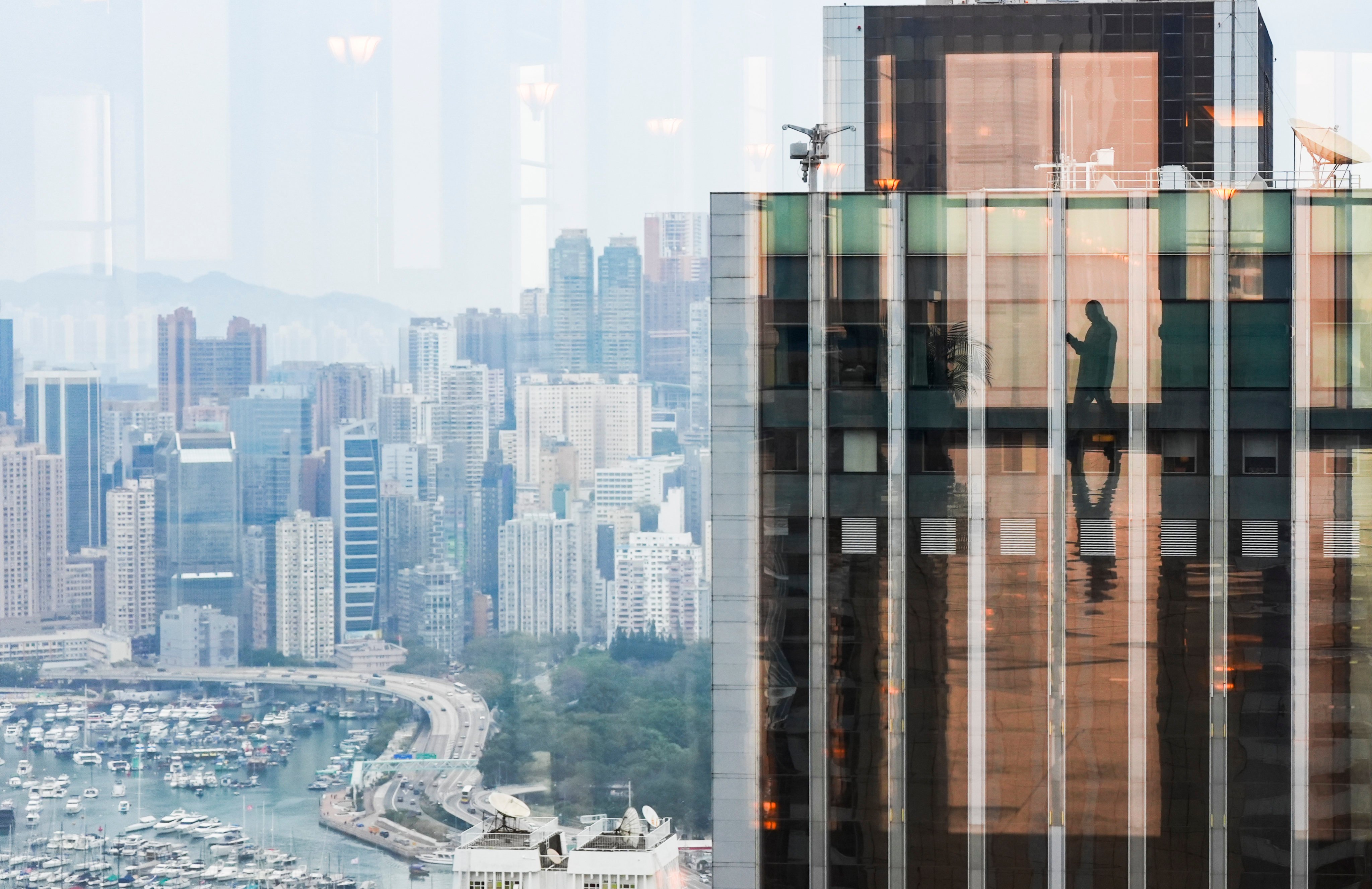 A mirror reflecting a person’s silouette is seen amid commercial and residential buildings on Hong Kong Island, on February 26. Photo: Eugene Lee