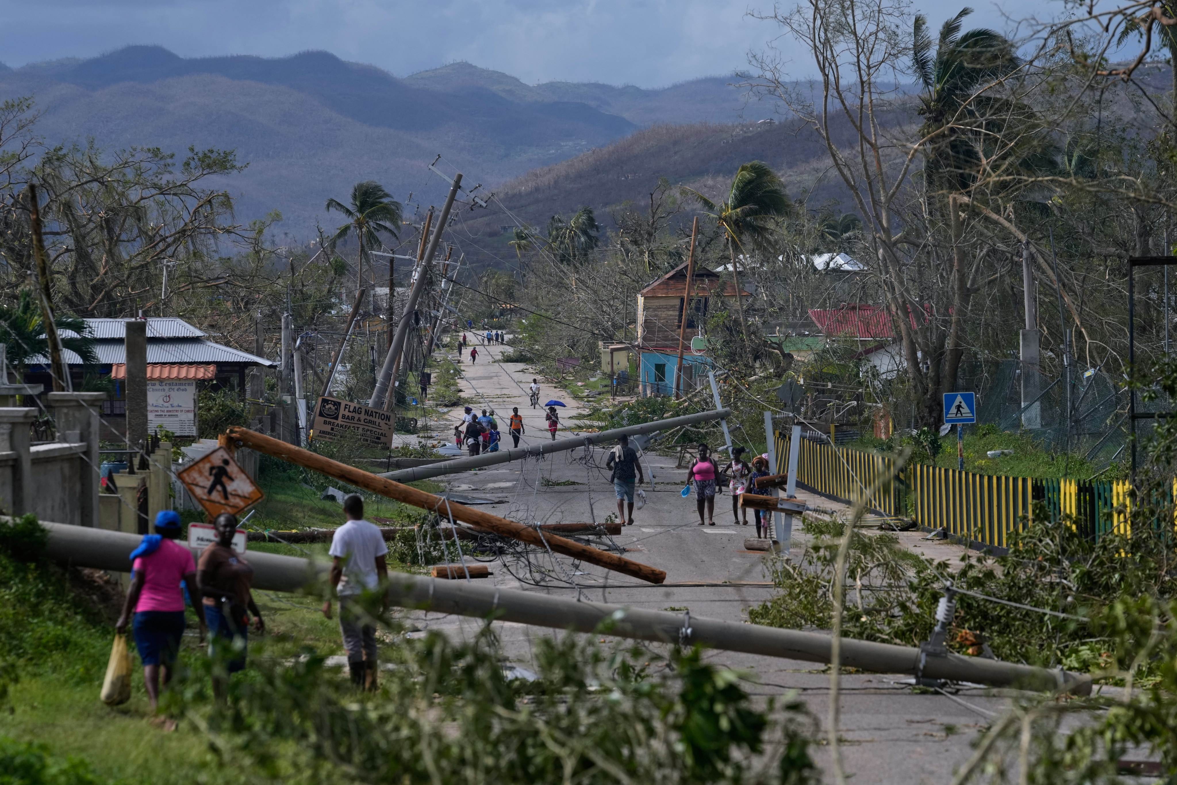 Residents walk through Lacovia Tombstone, Jamaica, in the aftermath of Hurricane Melissa. Photo: AP