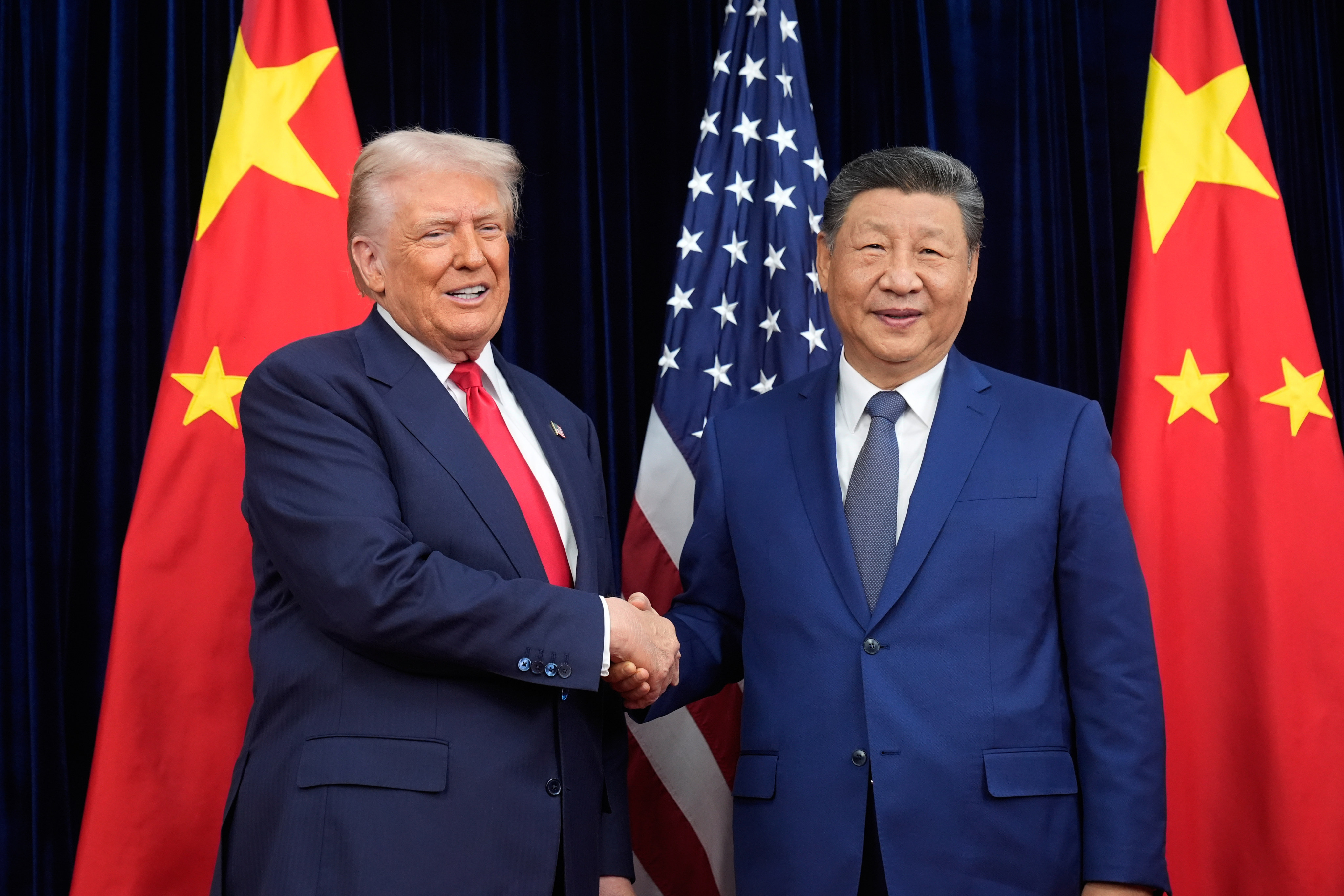 President Donald Trump and Chinese President Xi Jinping shake hands before their meeting at Gimhae International Airport in Busan, South Korea. Photo: AP