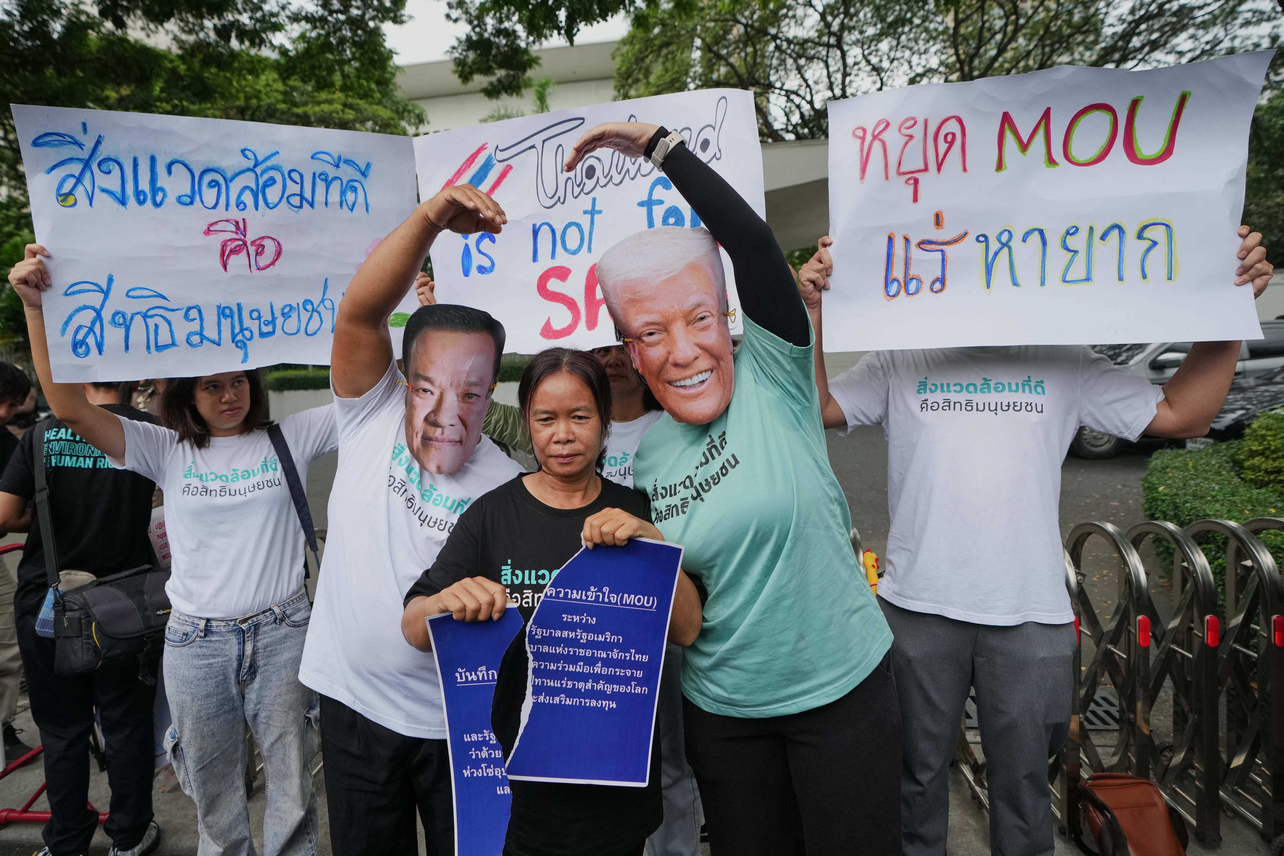 Activists wear masks of Thai Prime Minister Anutin Charnvirakul (left) and US President Donald Trump during a protest against an MOU between the two sides outside the US embassy in Bangkok on Thursday. Photo: AP