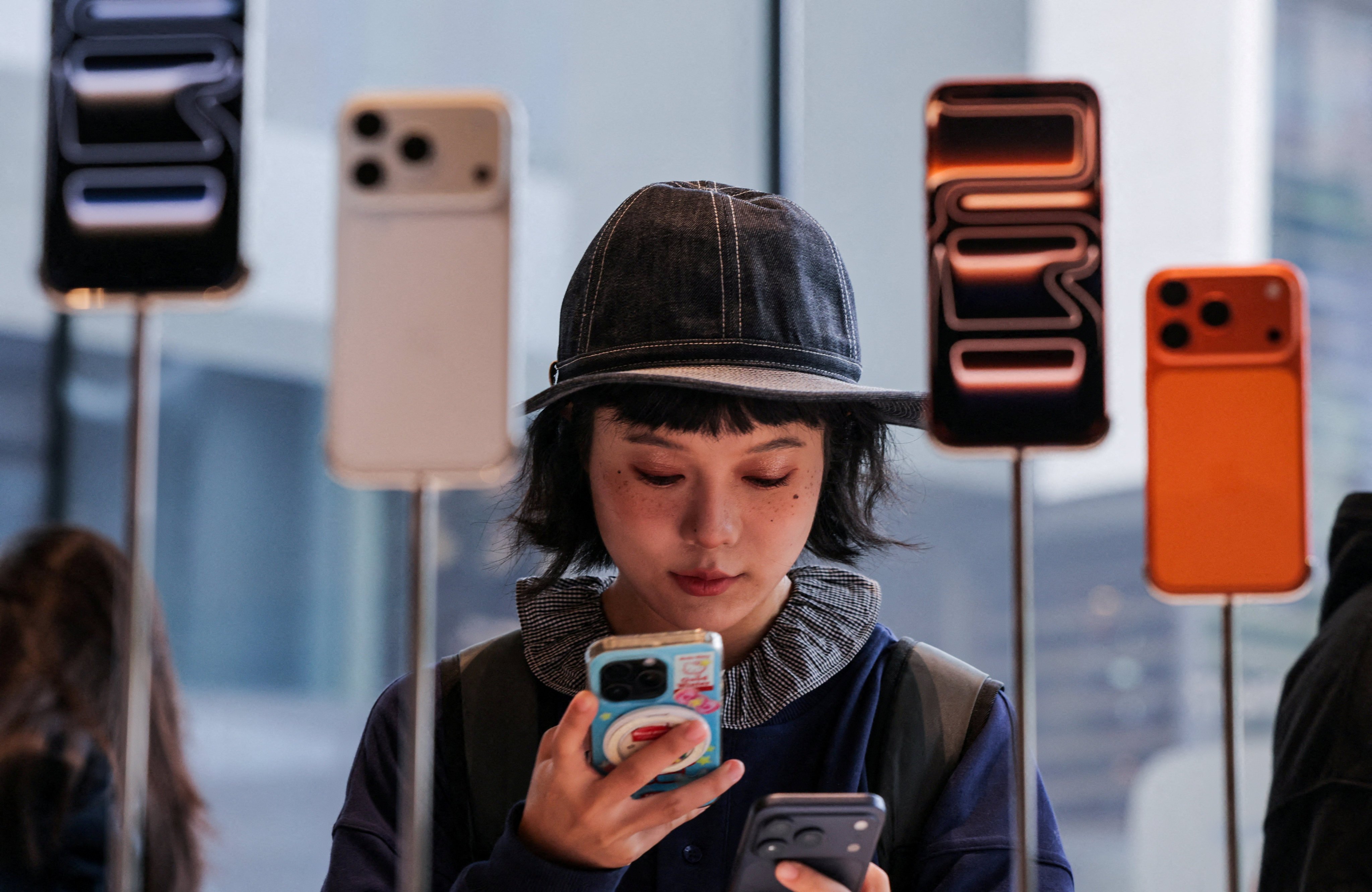 A woman checks out iPhones in an Apple store in Beijing’s Sanlitun area on September 19, 2025. Photo: Reuters