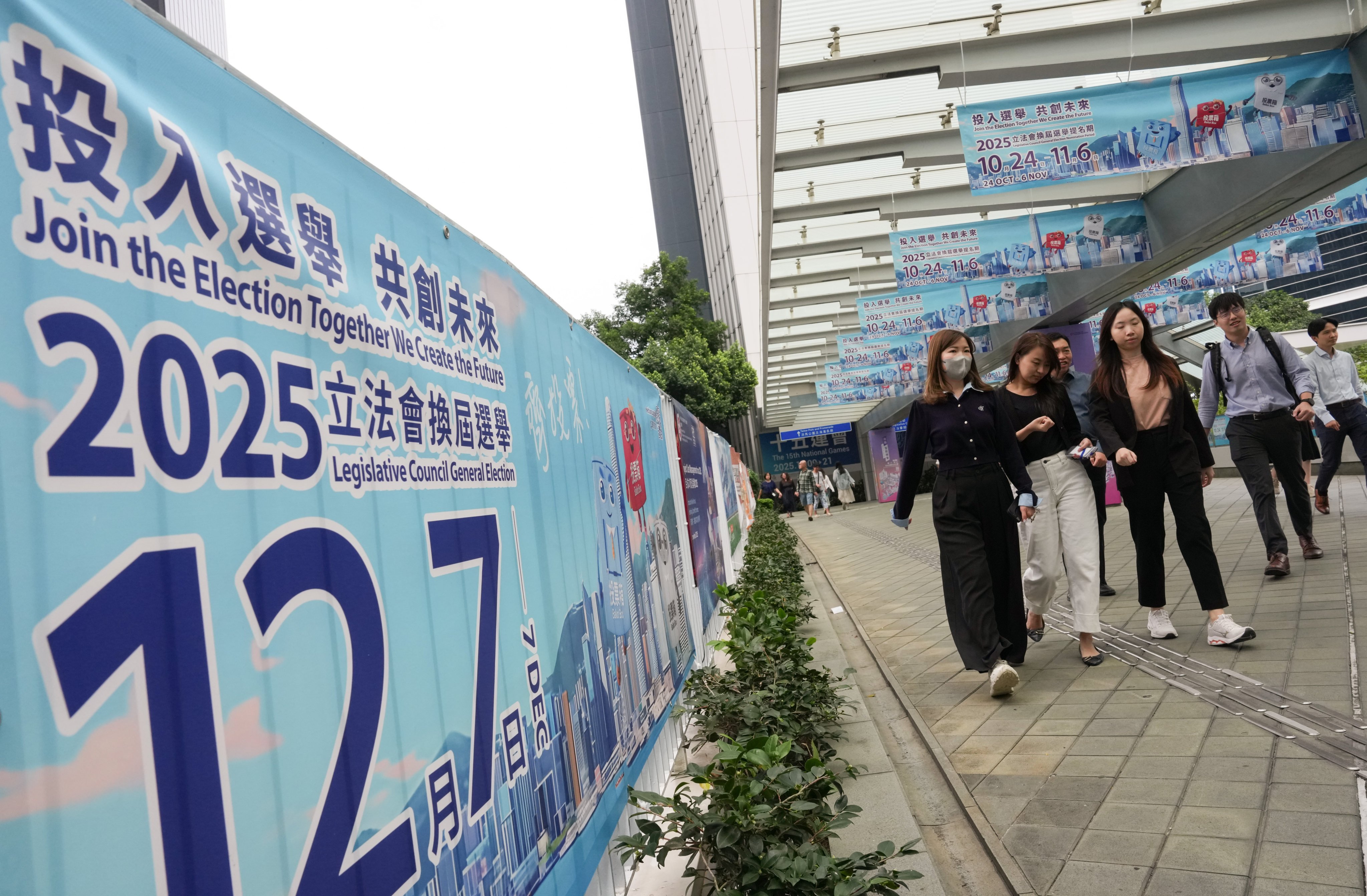 People walk past banners publicising the December 7 Legislative Council election at the government offices in Tamar on October 30. Photo: Jelly Tse