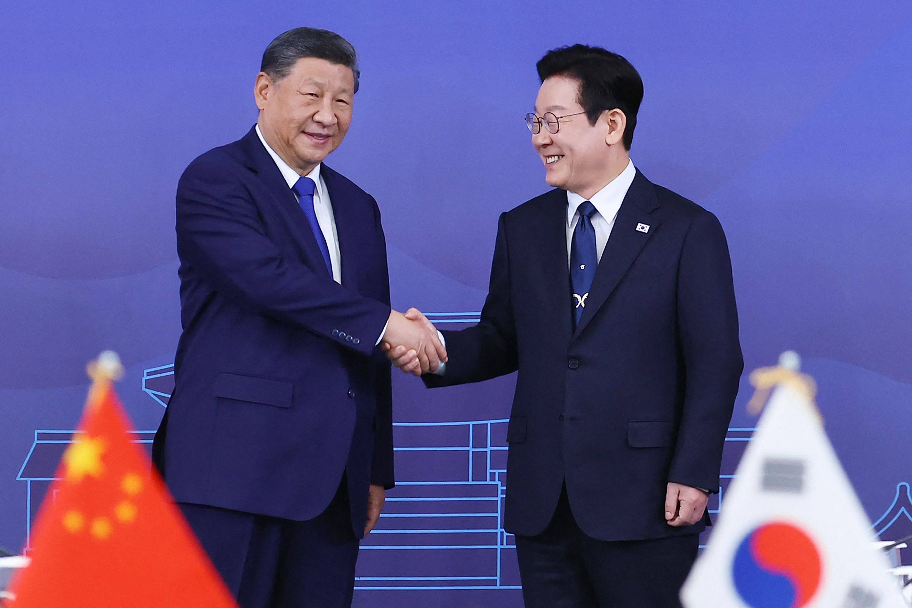 South Korea’s President Lee Jae Myung (right) and China’s President Xi Jinping shake hands ahead of the South Korea-China summit on Saturday in South Korea. Photo: Yonhap/AFP