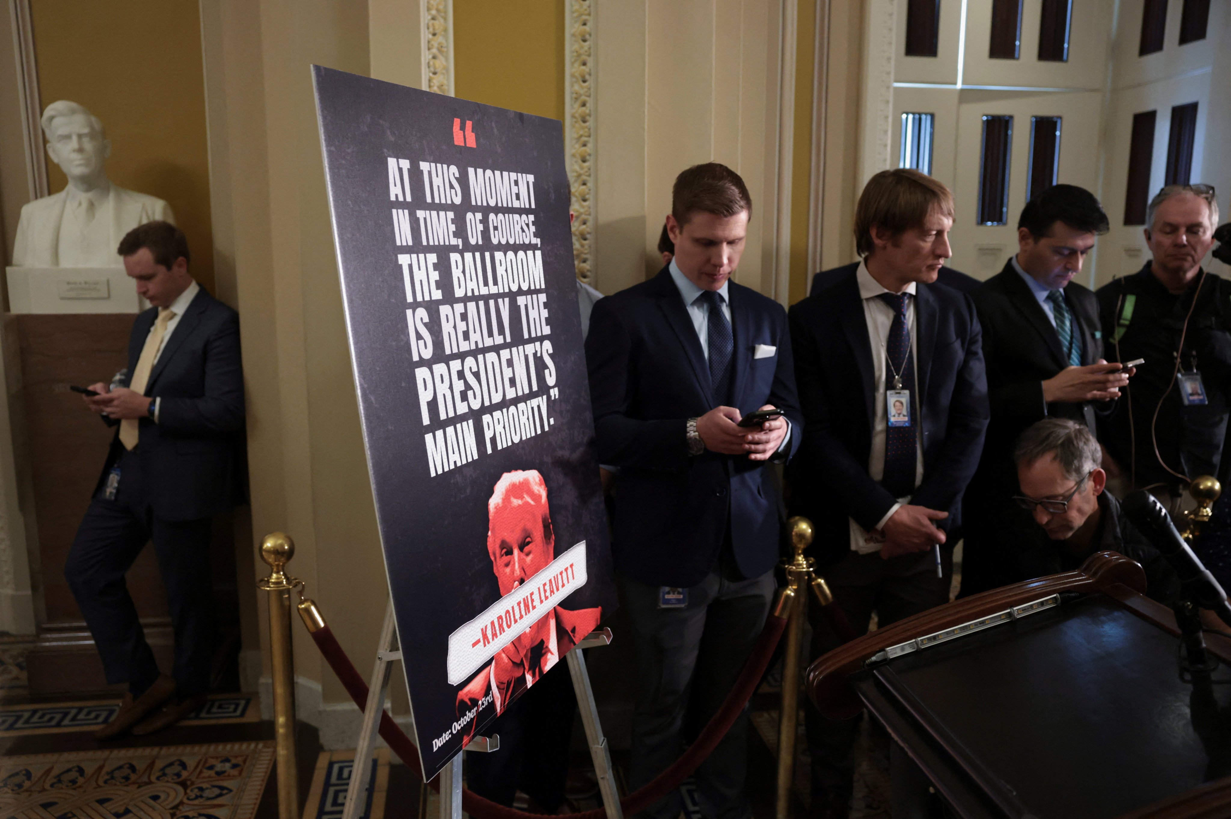 Reporters wait next to a poster featuring a quote attributed to White House Press Secretary Karoline Leavitt ahead of a press conference on Capitol Hill on Tuesday. Photo: Reuters