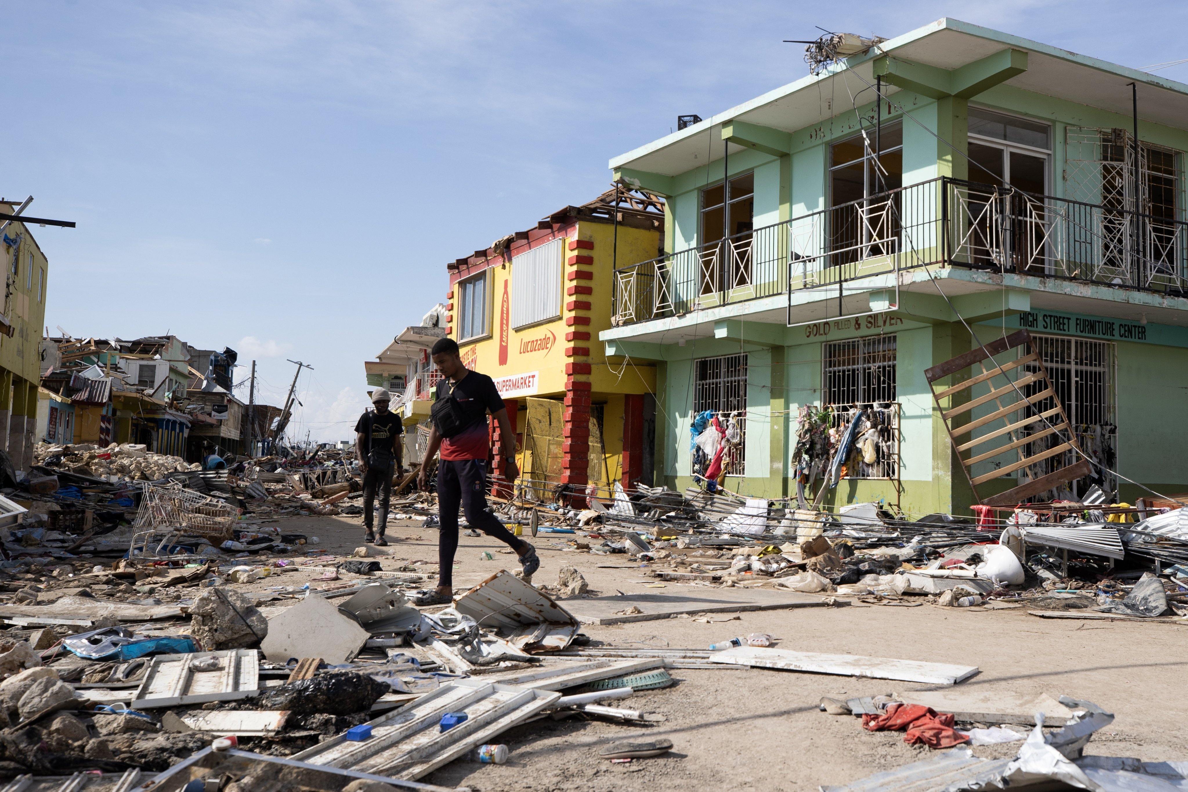 People walk along a street destroyed by Hurricane Melissa in Black River, Jamaica, on Friday. Photo: EPA