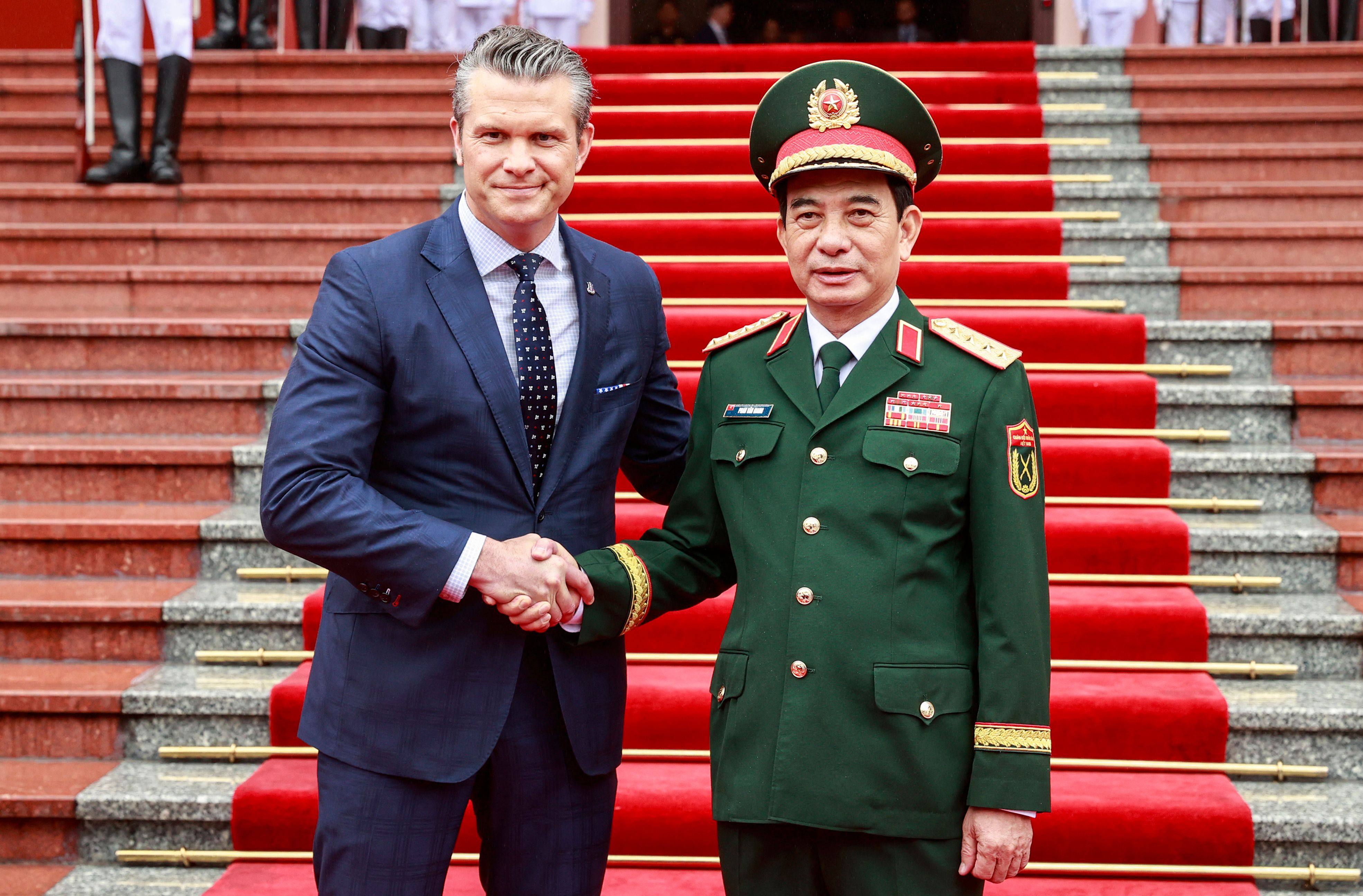 Vietnam’s Defense Minister Phan Van Giang (right) and US Defense Secretary Pete Hegseth shake hands during a welcoming ceremony at the Ministry of Defense headquarters in Hanoi on Sunday. Photo: AFP