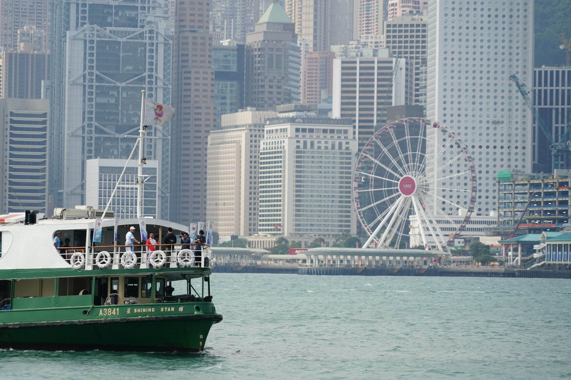 Li Ching takes the torch across Victoria Harbour on the Star Ferry. Photo: Felix Wong