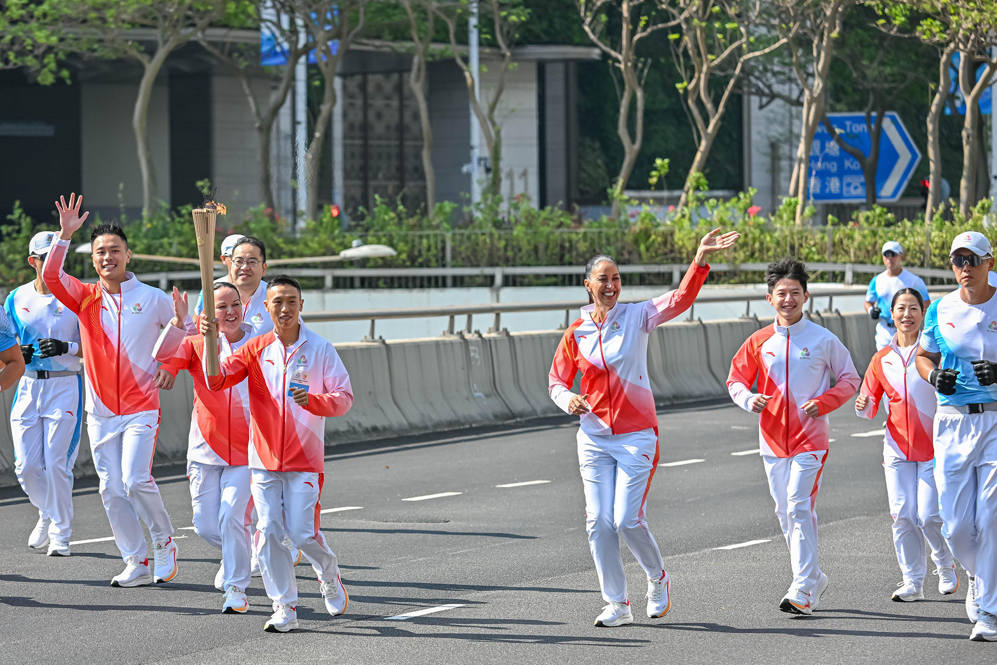 Jockey Vincent Ho carries torch during the National Games relay on Sunday morning. Photo: HKJC