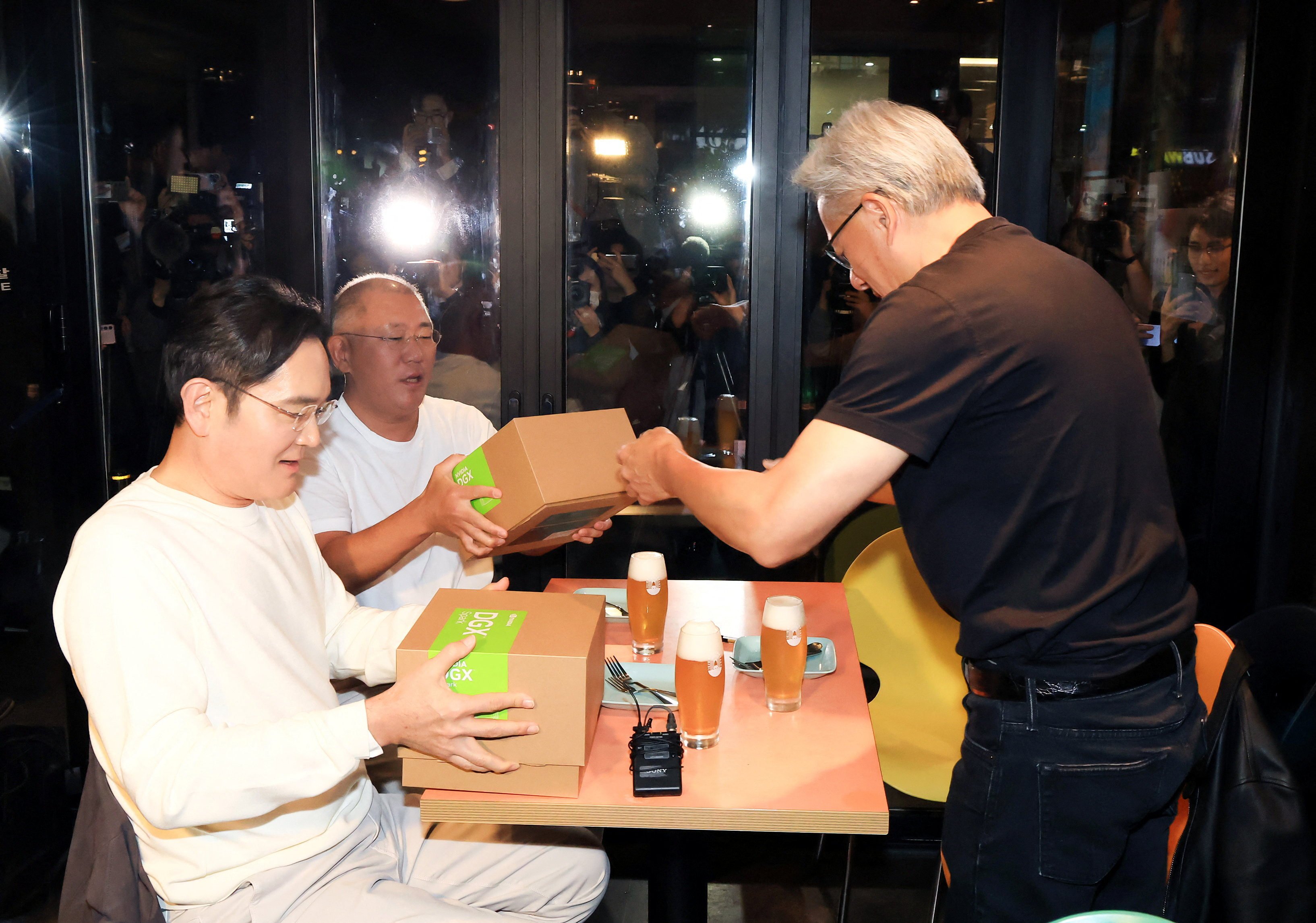Nvidia CEO Jensen Huang (right) gave gifts to Samsung Electronics Chairman Jay Y. Lee (left) and Hyundai Motor Group’s Executive Chair Chung Euisun (centre) during a dinner meeting at a fried chicken restaurant in Seoul on October 30, 2025. Photo: Yonhap