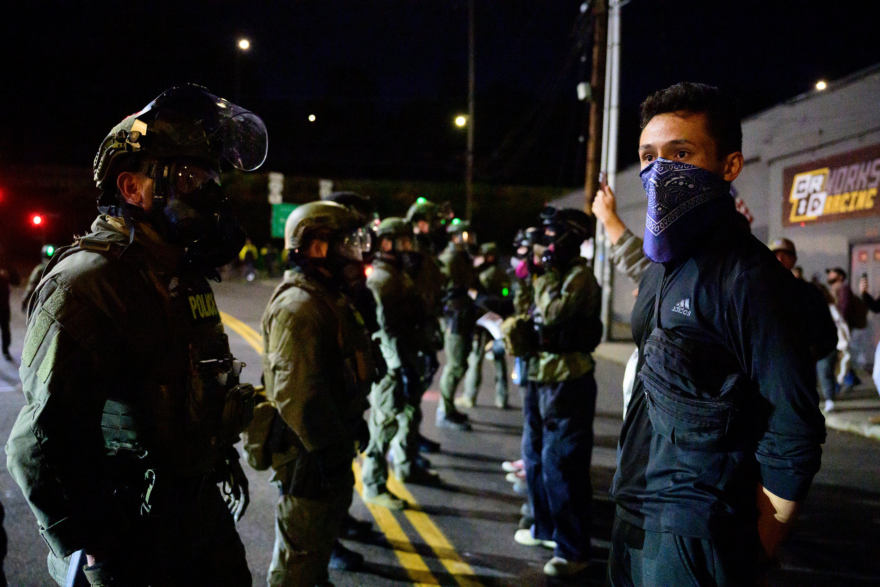 Federal agents stand guard to keep demonstrators away from an Immigration and Customs Enforcement facility in downtown Portland last month. Photo: TNS