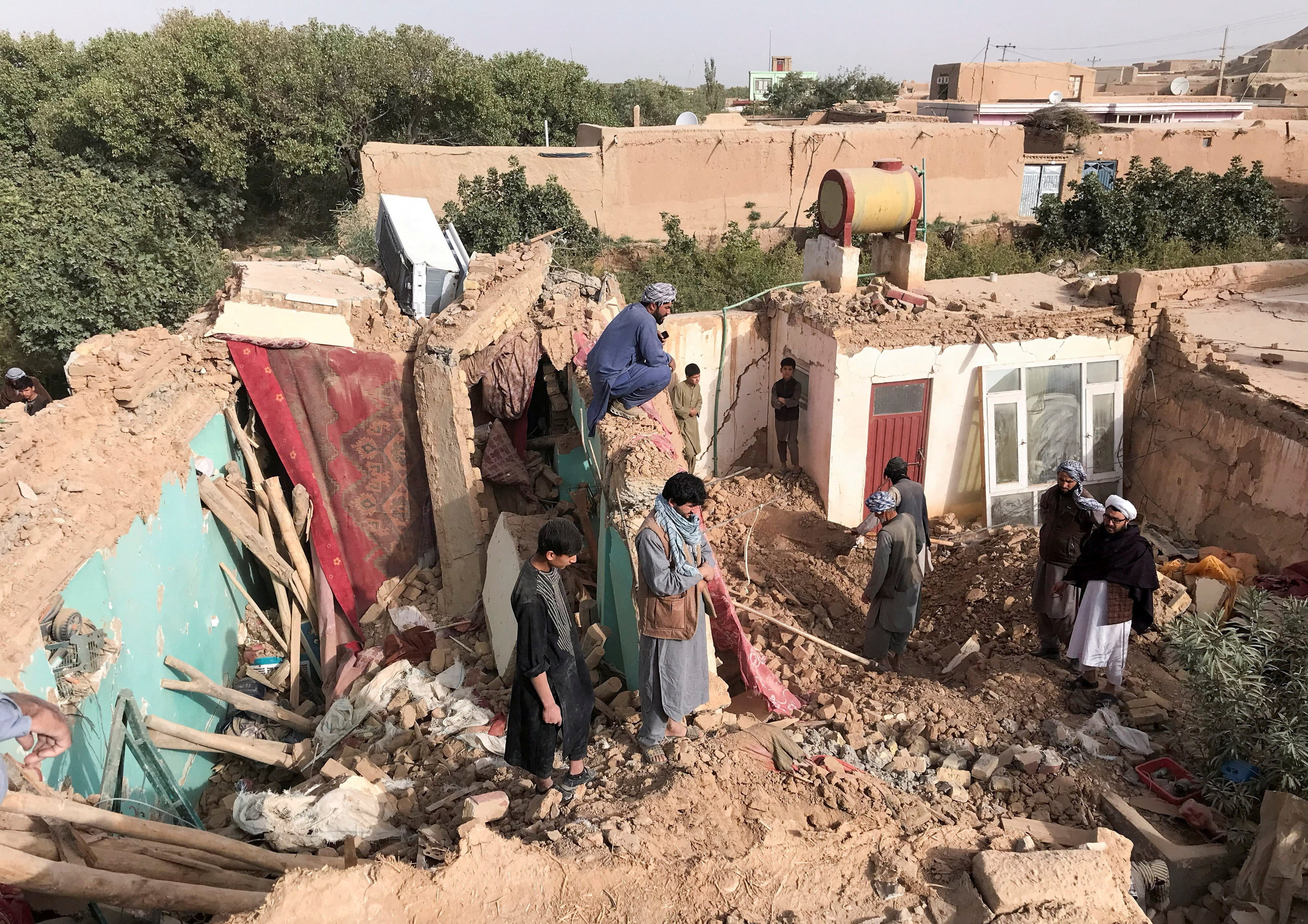 People stand on the debris of damaged buildings, in the aftermath of an earthquake in Samangan province, Afghanistan on Monday. Photo: Reuters