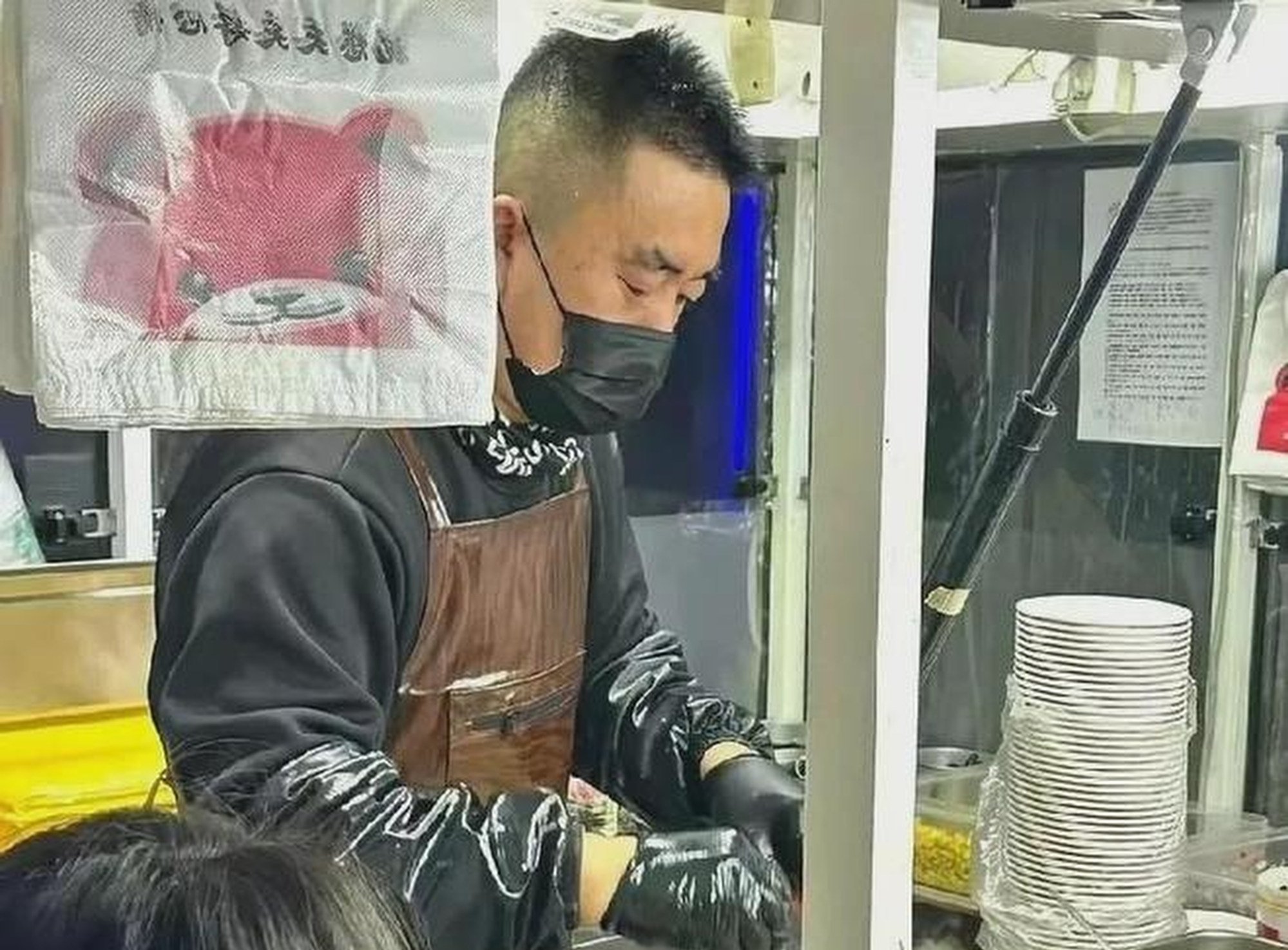 Li’s father cooks up a storm at his stall near the gates of his daughter’s university. Photo: Douyin