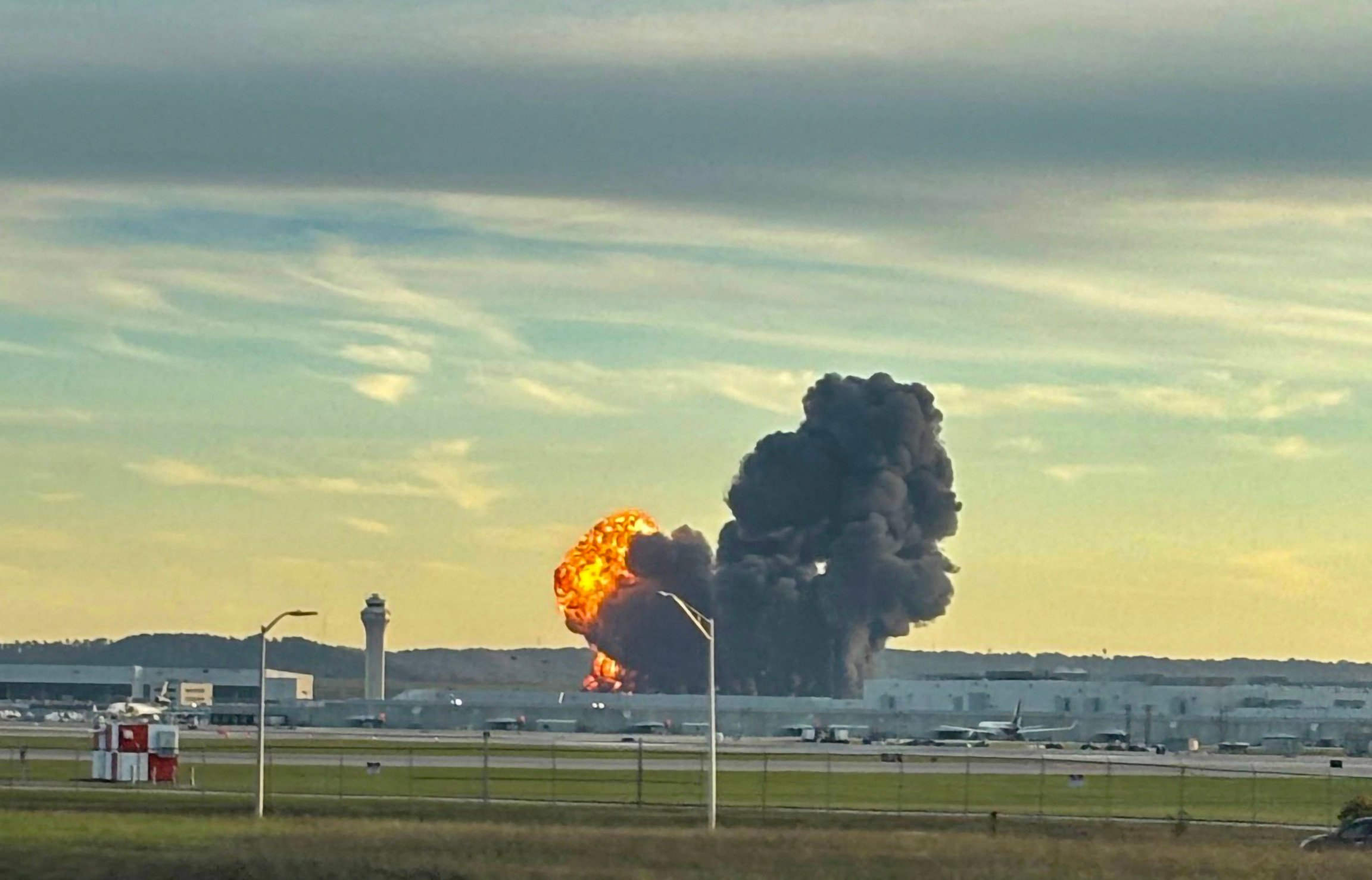 Smoke and flames rise from the site of a UPS cargo plane crash outside Louisville International Airport in Kentucky Tuesday. Photo: X/LeviDean98 via AFP