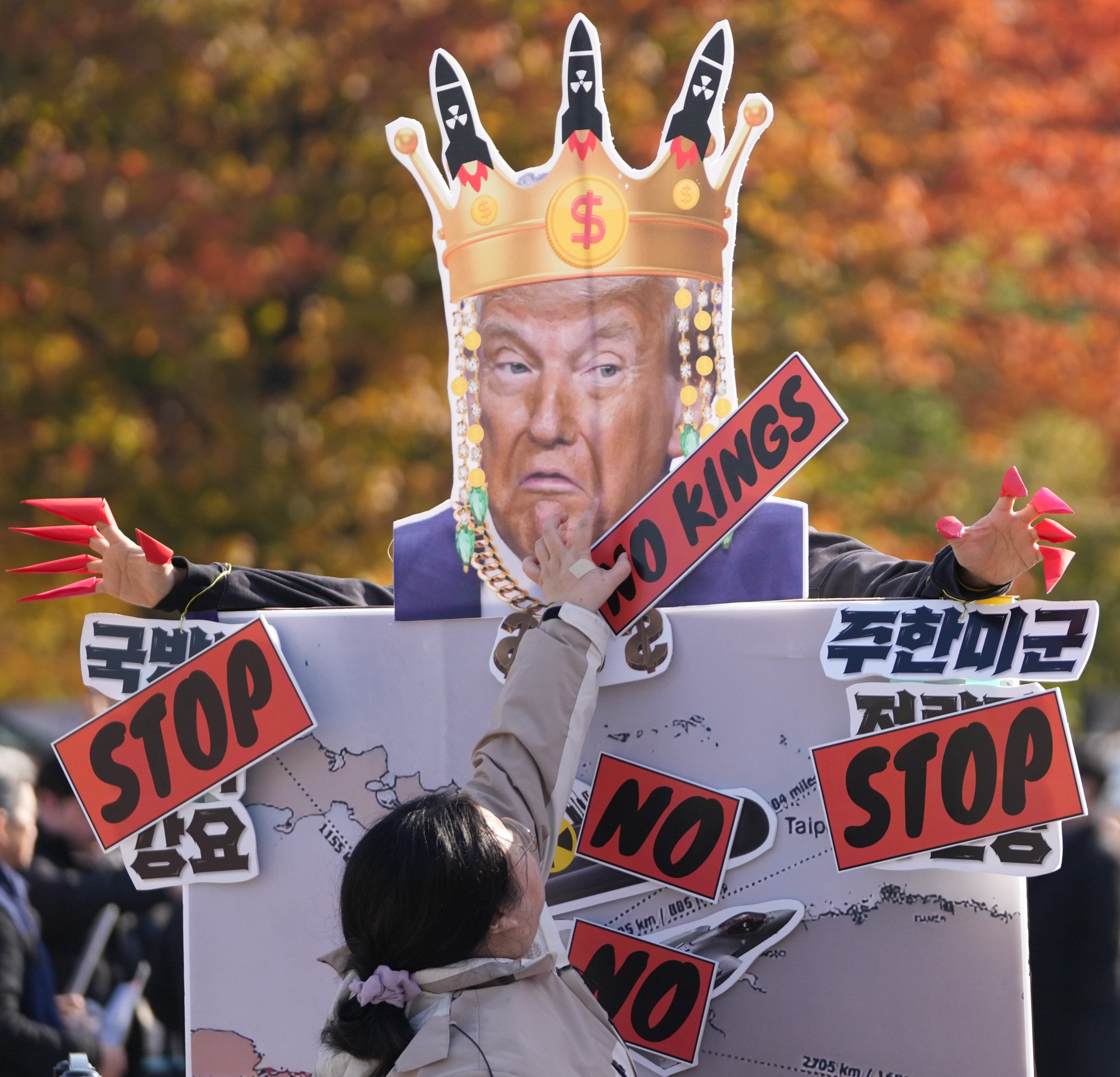 A protester puts a sign on a mask of US President Donald Trump during a rally to oppose the South Korean plan to acquire nuclear submarines in Seoul on Tuesday. Photo: AP A protester puts a sign on a mask of US President Donald Trump during a rally to oppose the South Korean plan to acquire nuclear submarines in Seoul on Tuesday. Photo: AP