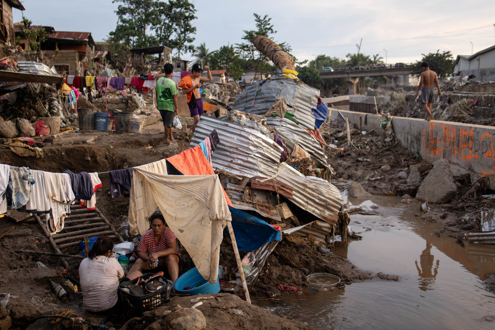 People wash their clothes at a community where houses were swept in the floods brought on by Typhoon Kalmaegi in Talisay, Cebu, the Philippines, on Thursday. Photo: Reuters People wash their clothes at a community where houses were swept in the floods brought on by Typhoon Kalmaegi in Talisay, Cebu, the Philippines, on Thursday. Photo: Reuters