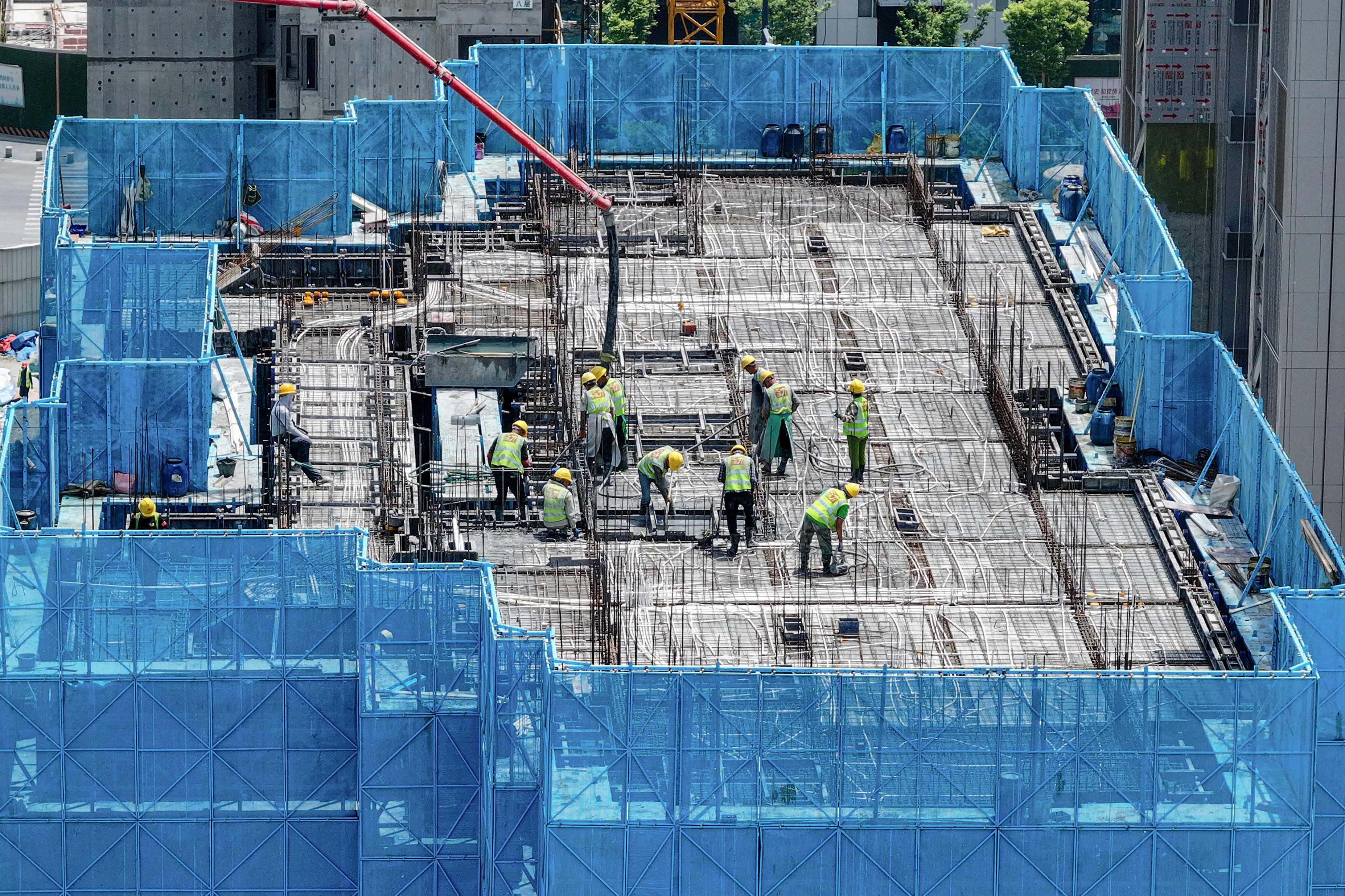 Workers are seen on a rooftop of a residential building under construction by Chinese property developer Poly Real Estate in Nanjing, in eastern China’s Jiangsu province, in May. Photo: AFP/China OUT