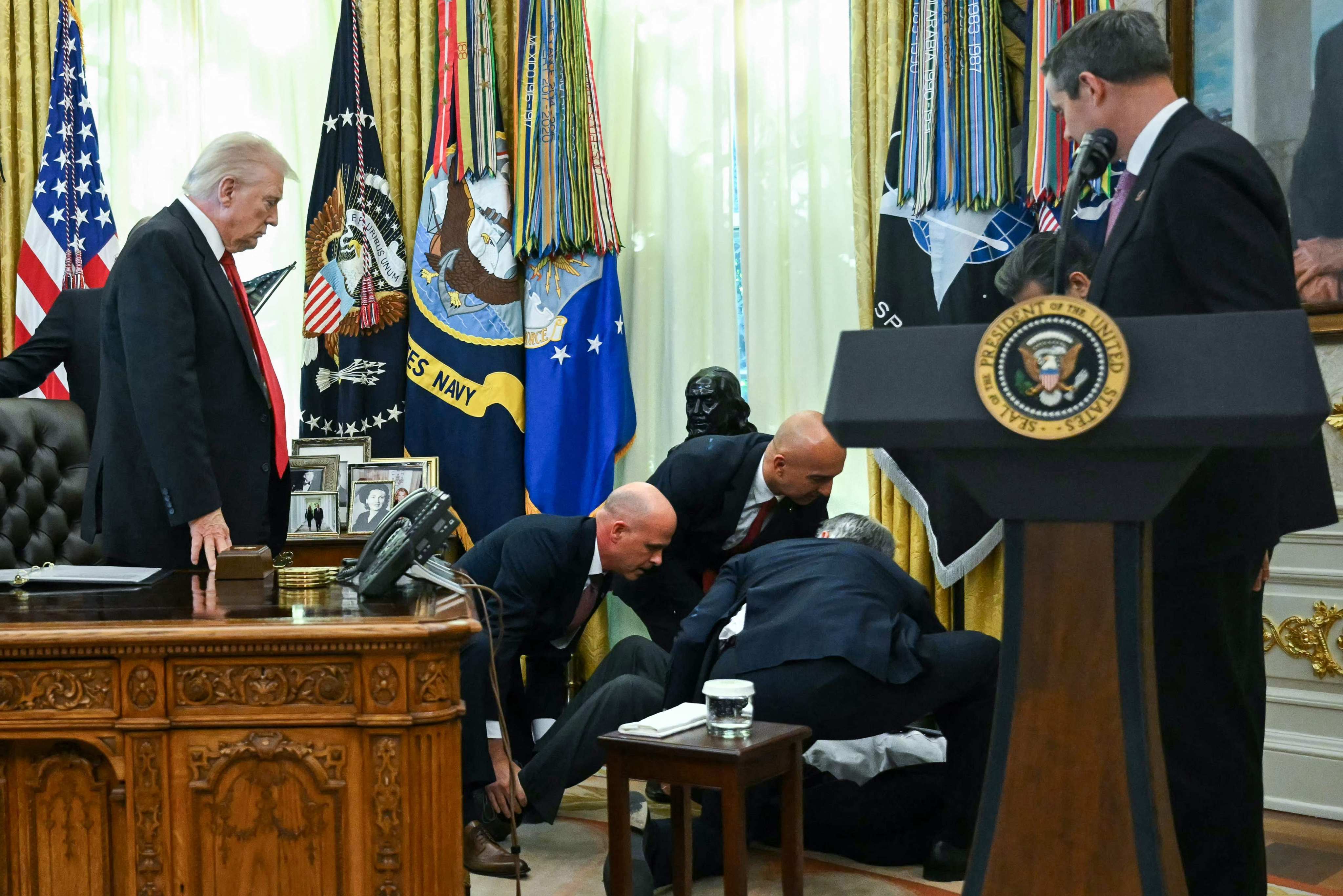 US President Donald Trump looks on after a man fainted in the Oval Office. Photo: AFP