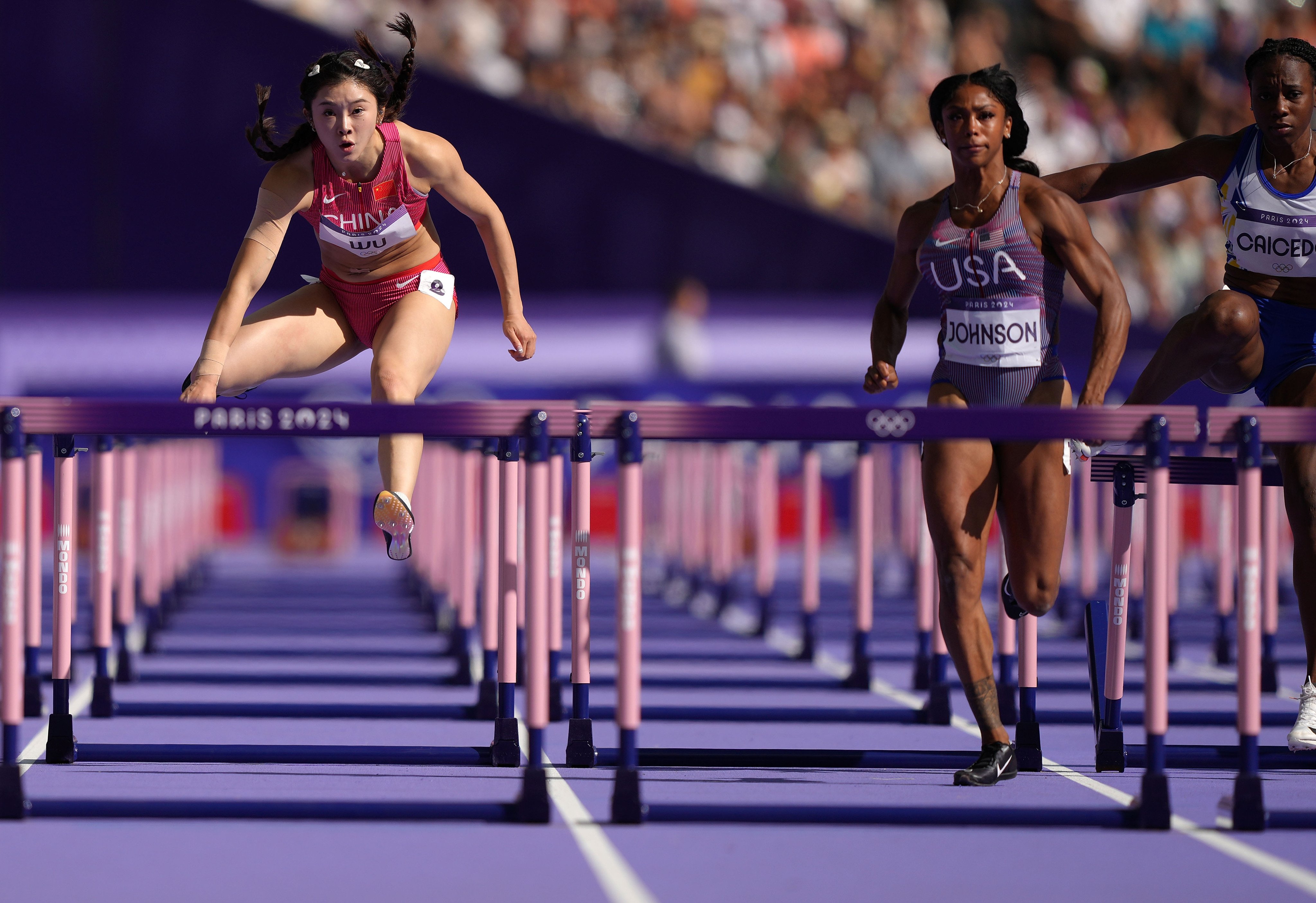 Wu Yanni (left) in round one of the 100m hurdles at the Paris Games, where she clocked China’s best time at the Olympics. Photo: Xinhua