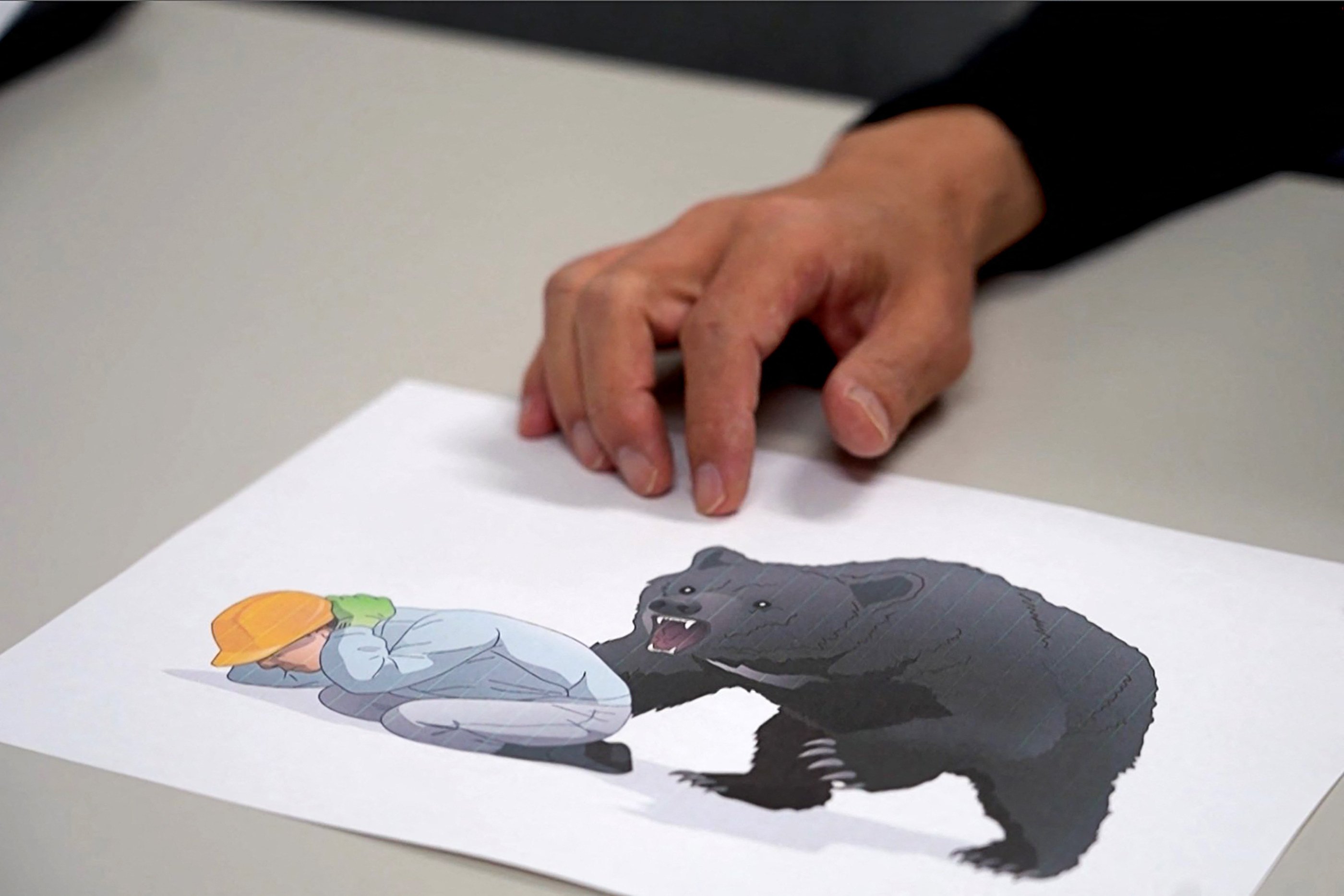 Japanese emergency doctor Hajime Nakae shows an illustration about bear attack safety at Akita University Hospital. Photo: AFTV/AFP