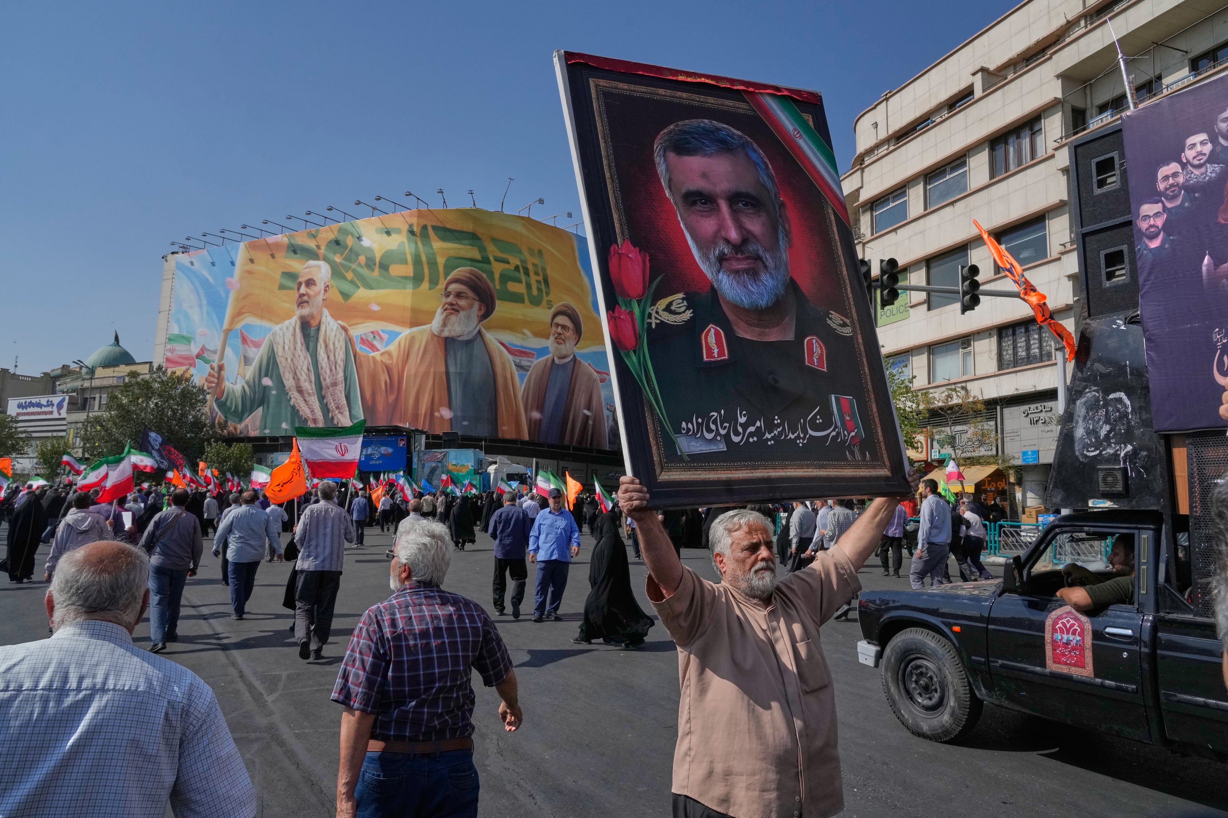 A man in Tehran  in October holds a portrait of Iran’s Revolutionary Guard General Amir Ali Hajizadeh, who was killed in an Israeli strike in June, while a banner shows Quds Force General Qassem Soleimani (left), who was killed in a US drone attack in 2020, and two late Hezbollah leaders. Photo: AP