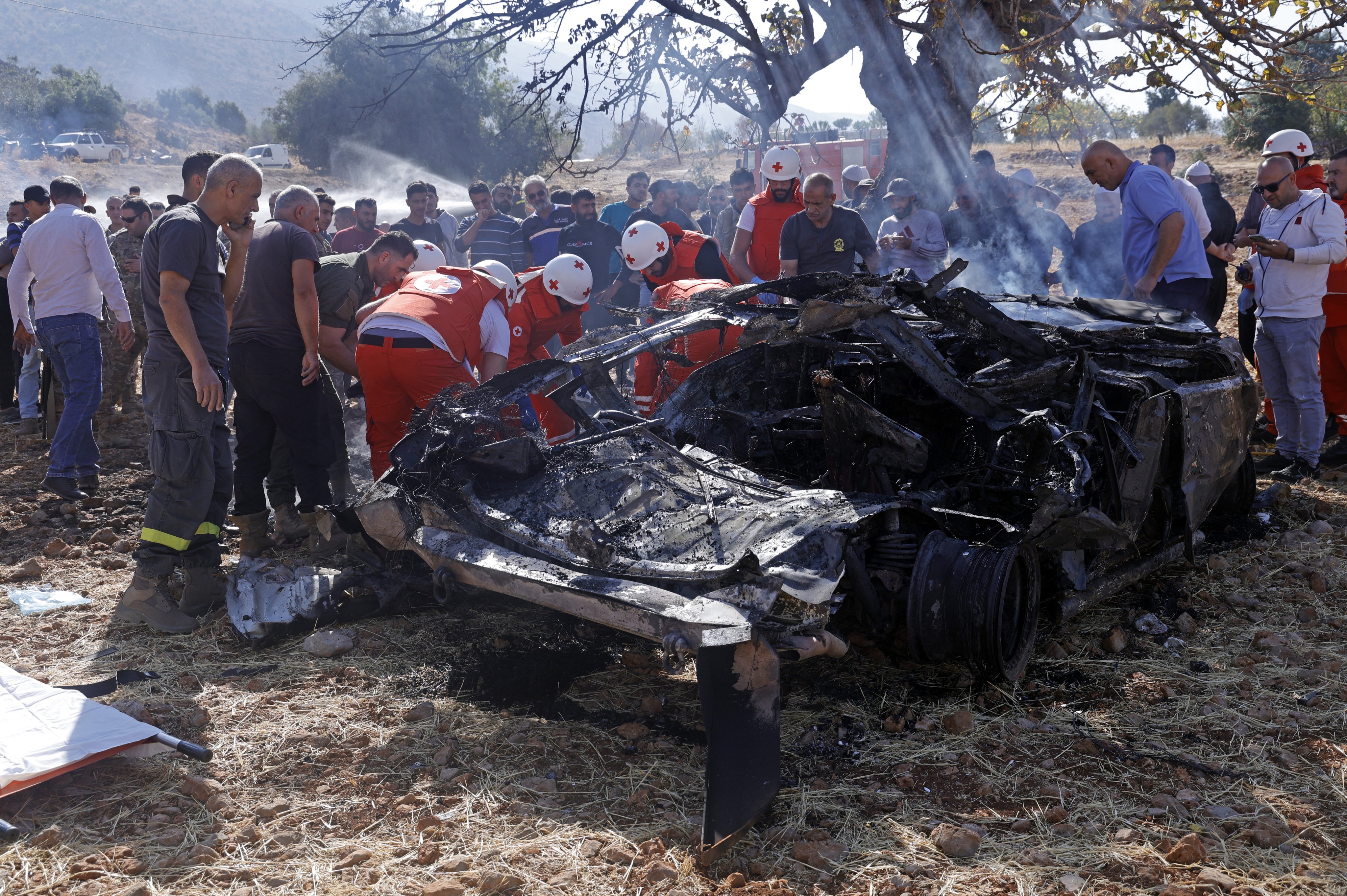 Members of the Lebanese Red Cross inspect the wreckage of a vehicle struck by an Israeli drone in the town of Shebaa on Saturday. Photo: EPA