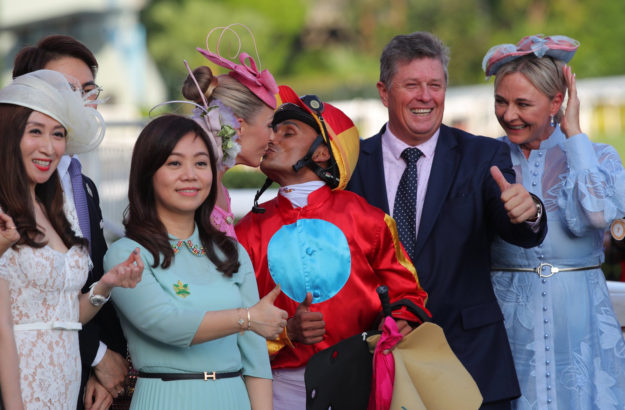 Jockey Karis Teetan kisses his wife Xaviere while trainer Brett Crawford gives the thumbs up.