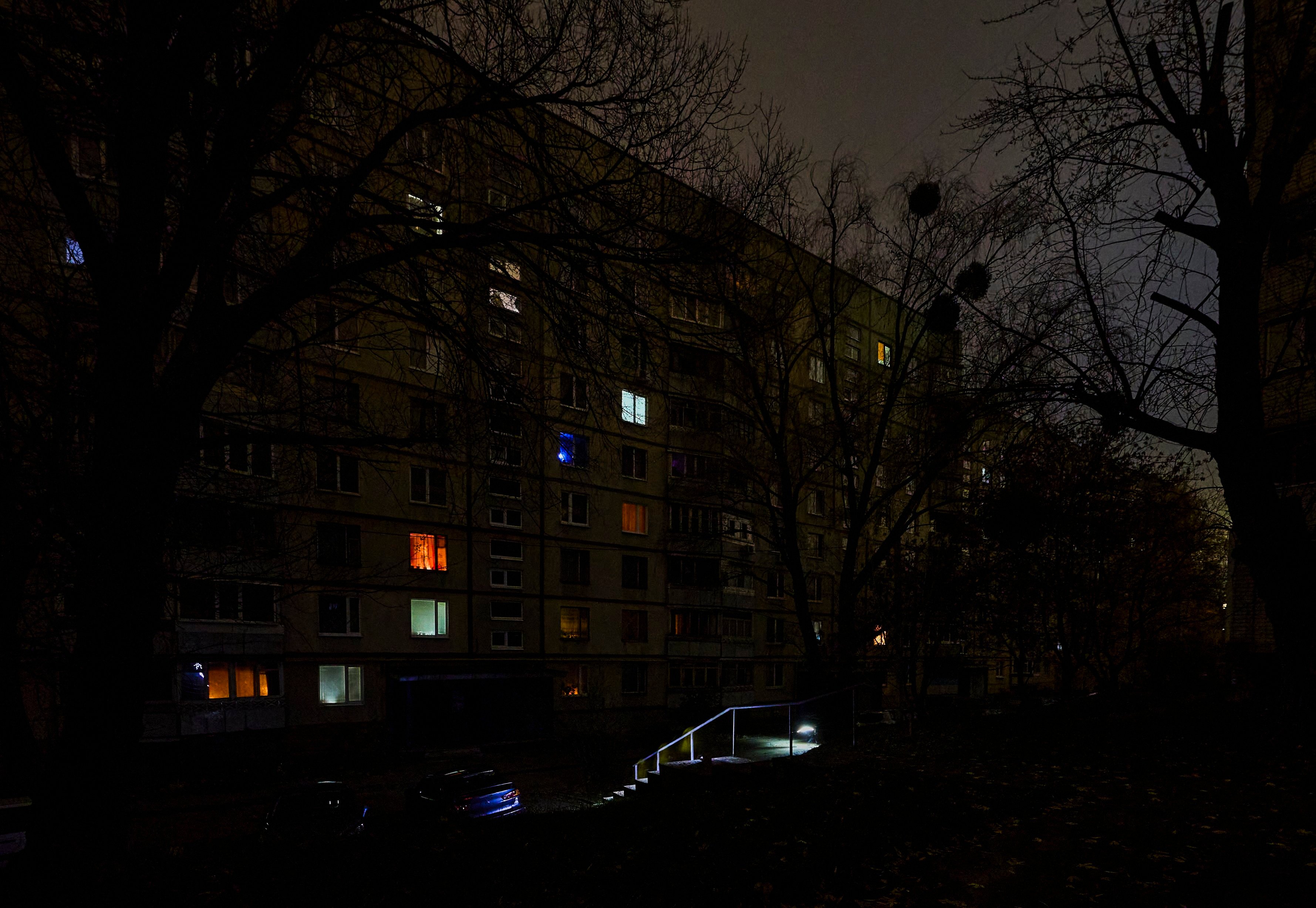 People walk with flashlights on a dark street during a blackout in Kharkiv, Ukraine, on Saturday. Photo: EPA
