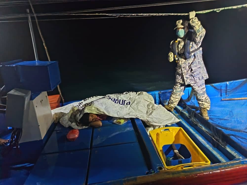 A survivor (left) rests aboard a boat in the waters off Kedah, Malaysia, on Sunday. Photo: Malaysian Maritime Enforcement Agency/Xinhua