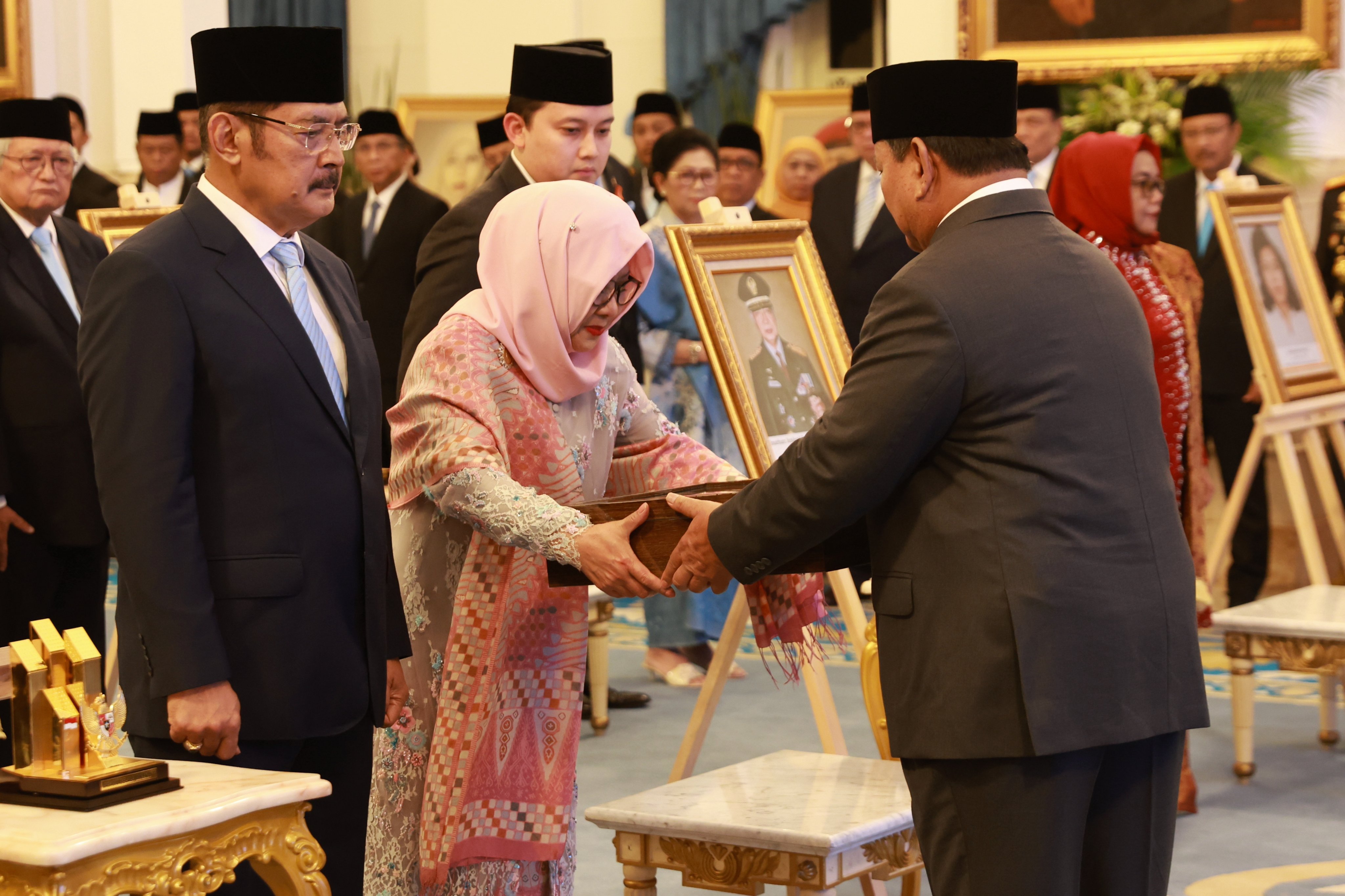 Indonesian President Prabowo Subianto (right) gives a placard to Suharto’s daughter Siti Hardiyanti Rukmana and son Bambang Trihatmodjo. Photo: EPA