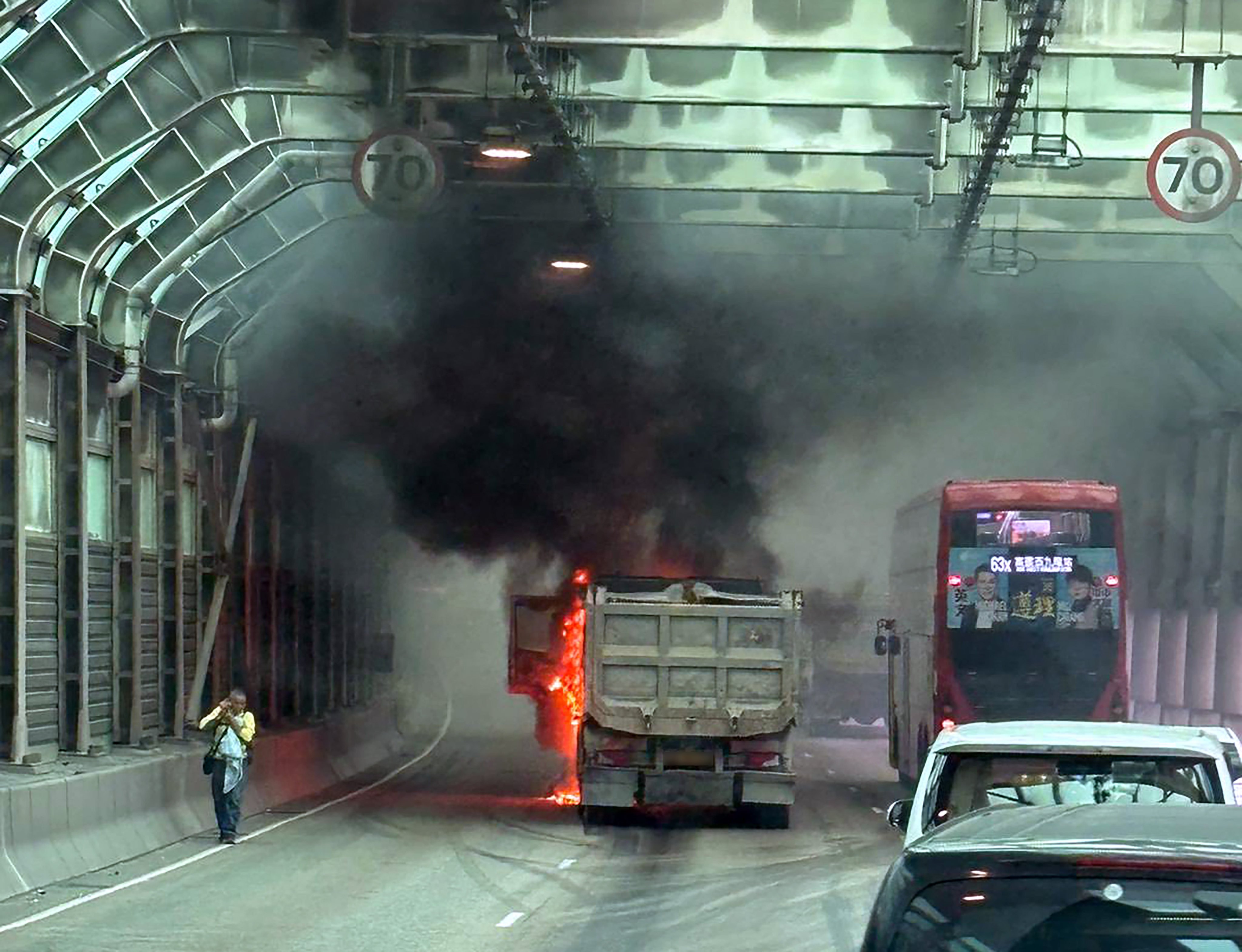 The truck on fire on Tuen Mun Road, with the driver calling emergency services from the side of the thoroughfare. Photo: Handout