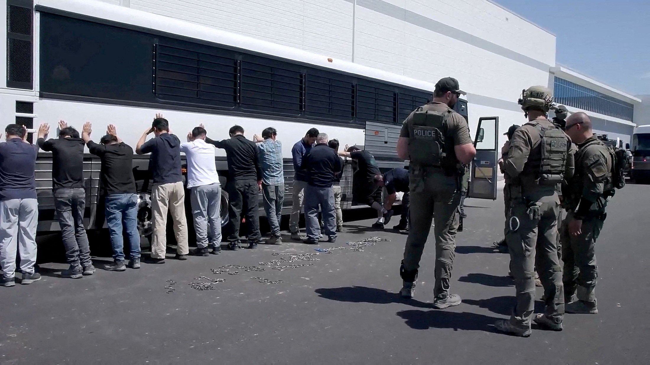 Detainees are made to stand against a bus before being handcuffed, during a raid by federal agents in Ellabell, Georgia, in September. Photo: US Immigration and Customs Enforcement/Reuters