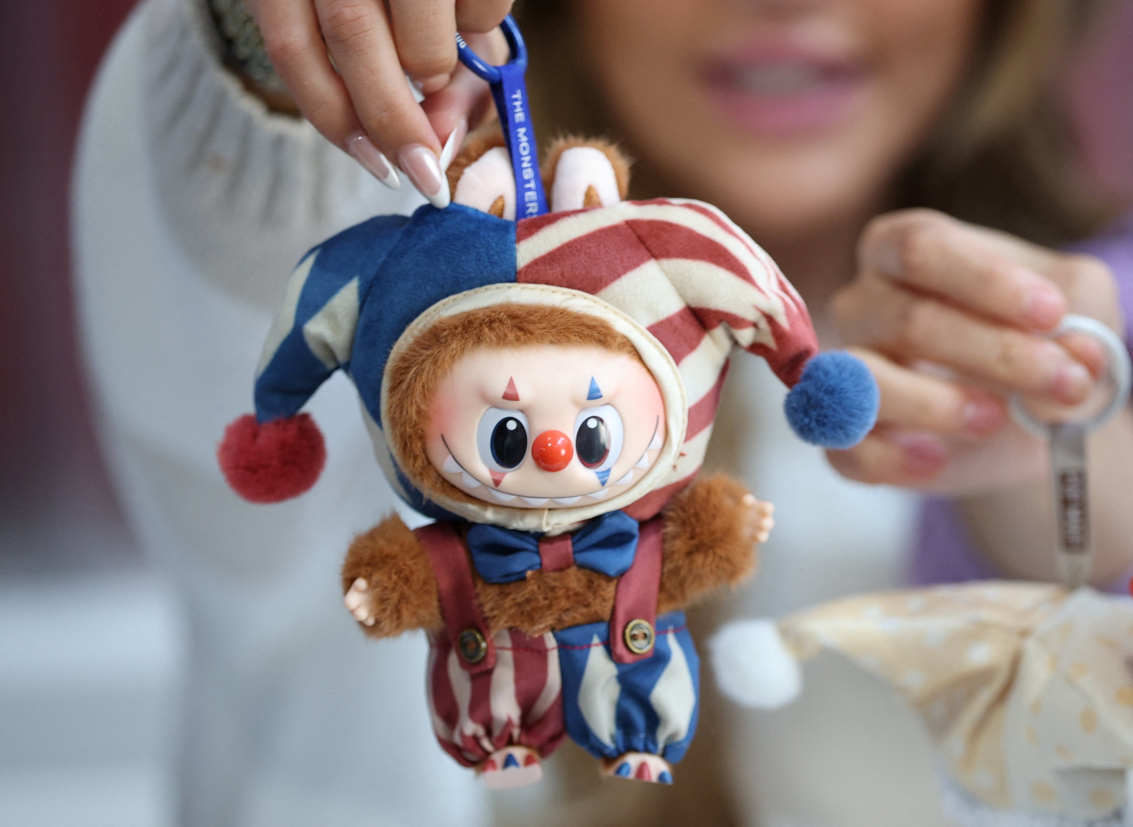 An influencer holds a Labubu Why So Serious Plush Pendant doll during an AliExpress and Pop Mart livestream shopping show on Singles' Day at a pop-up store in London, Britain, November 11, 2025. REUTERS/Isabel Infantes