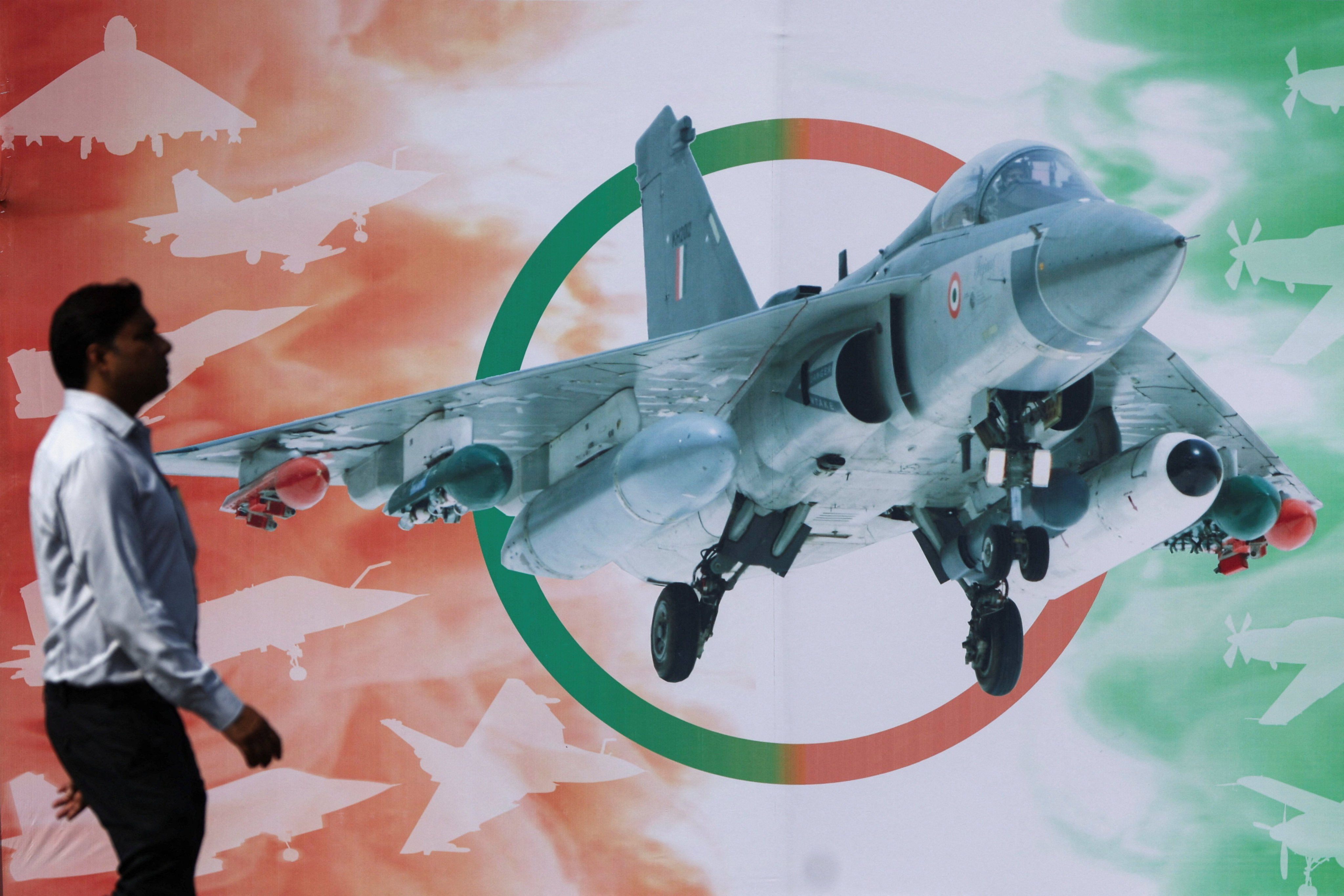 A man walks past a poster of Hindustan Aeronautics Limited’s Tejas Mark 1A light combat aircraft ahead of its maiden flight at HAL in Nashik, India, on October 17. Photo: Reuters