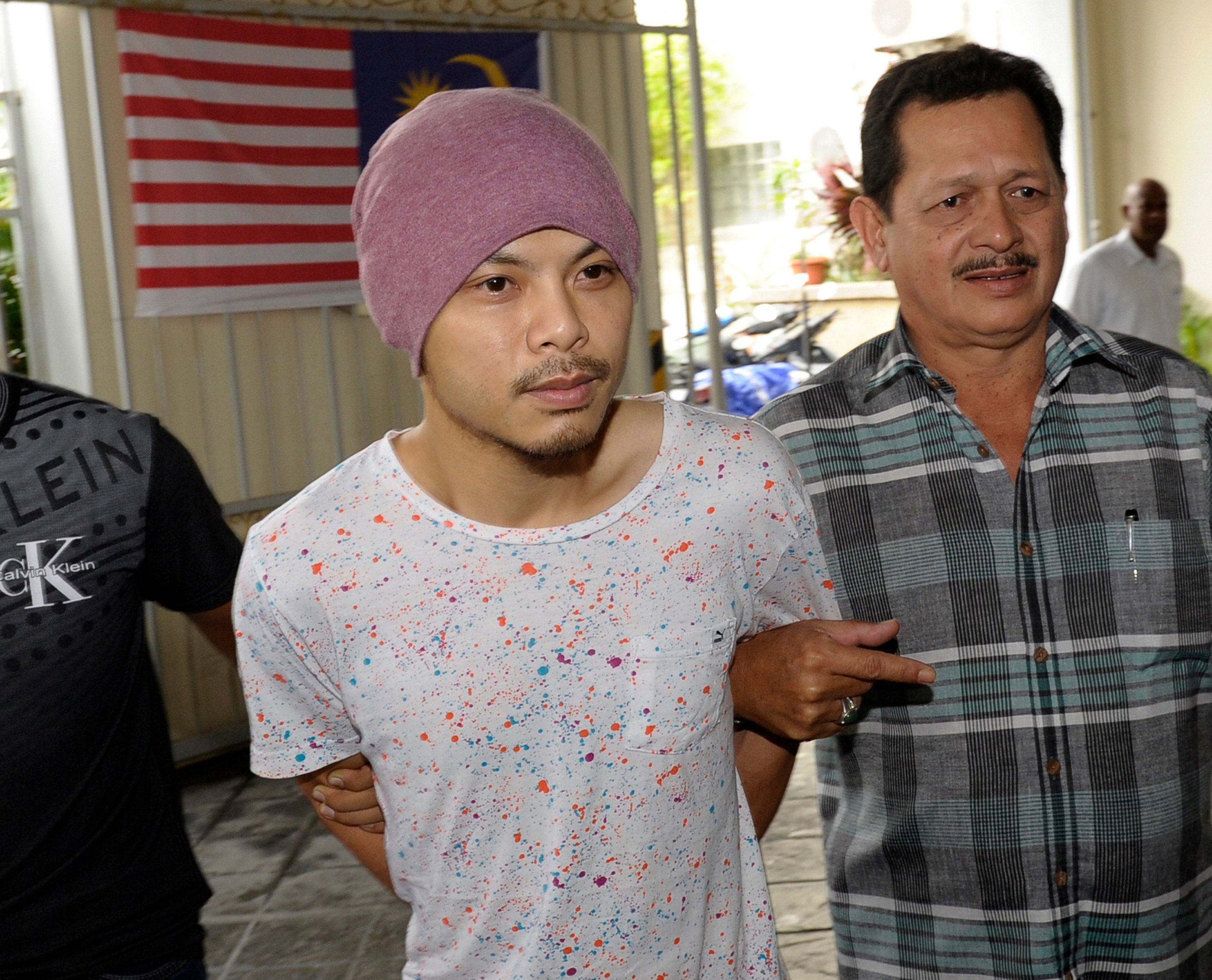 FILE - Wee Meng Chee, left, a Malaysian rapper popularly known as Namewee, is escorted by plainclothes policemen on his arrival at the magistrate court in Penang, Malaysia, Aug. 22, 2016. (AP Photo/Gary Chuah, File)
