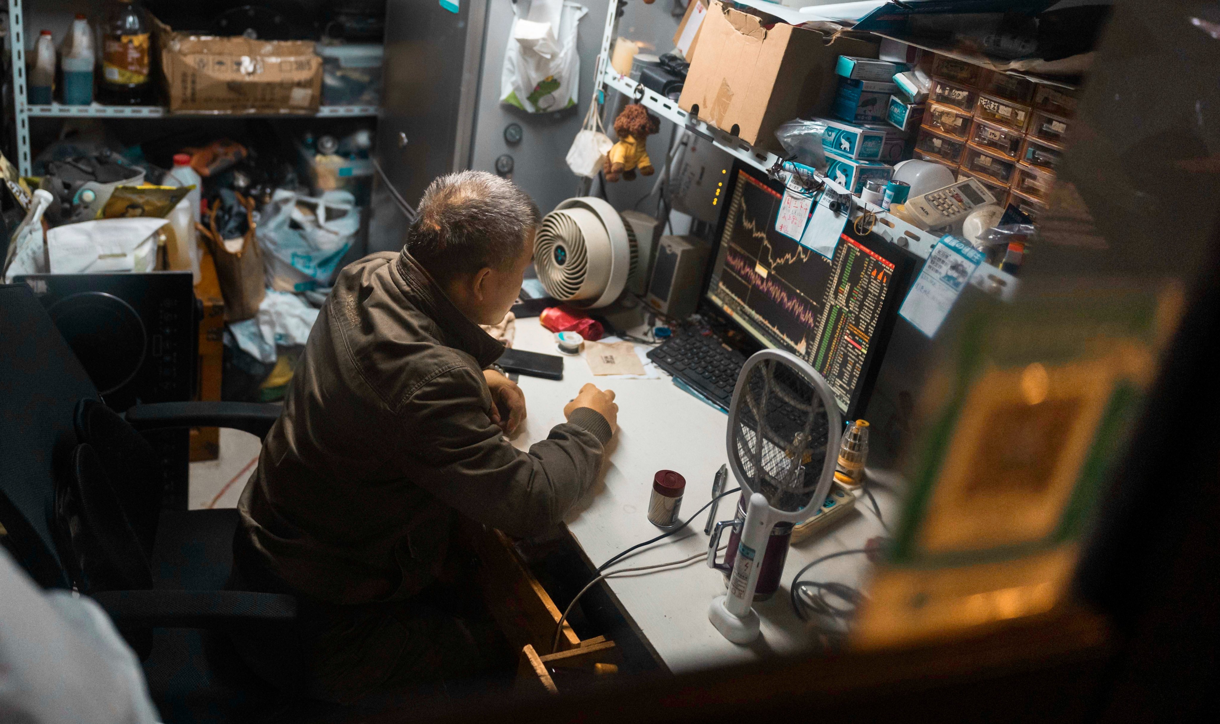 A man checks the latest stock exchange data on a computer screen at his shop in Shanghai on October 30. Photo: EPA